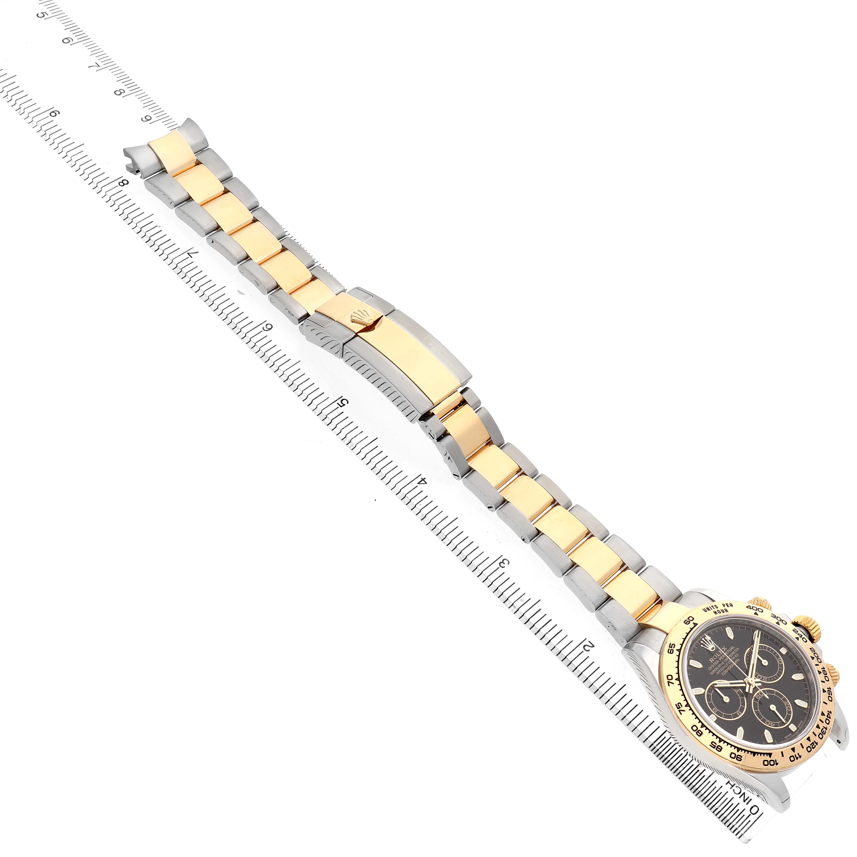 The image shows a top view of a Rolex Daytona 116503 Men's Stainless Steel Black Dial watch with its bracelet extended alongside a ruler.