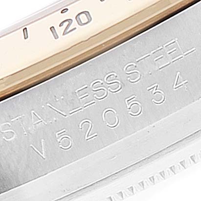 The image shows a close-up of the case side and bezel of a Rolex Daytona 116523 Men's Steel and Gold (two tone) Blue Dial 116523 Men's Steel and Gold (two tone) Blue Dial watch, displaying its serial number and inscription.