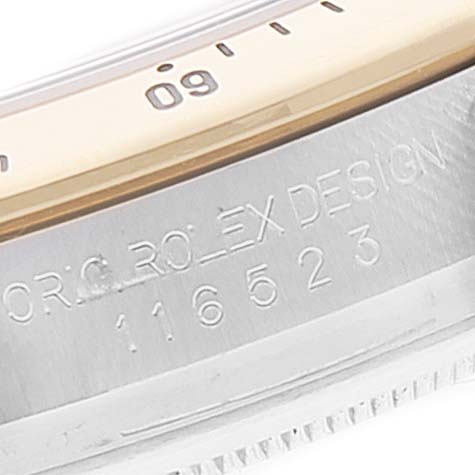 This image shows a close-up of the side engraving and part of the bezel of a Rolex Daytona 116523 Men's Steel and Gold (two tone) Blue Dial 116523 Men's Steel and Gold (two tone) Blue Dial watch.
