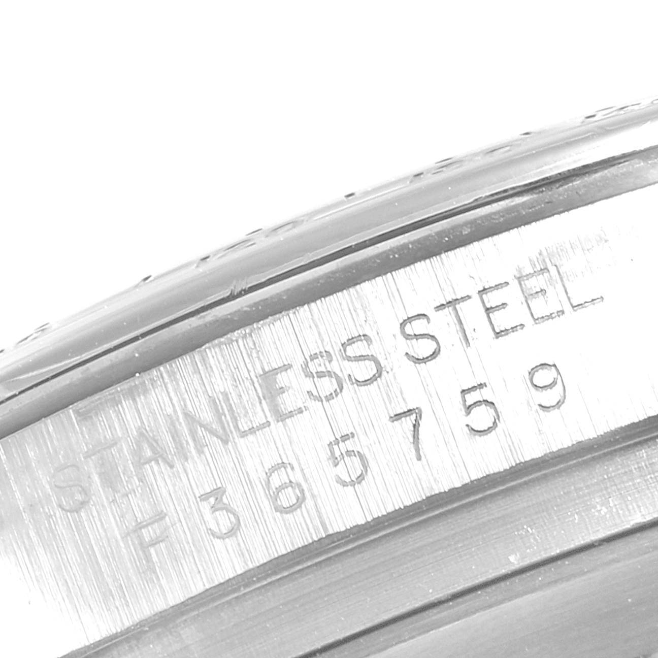 This image shows a close-up of the serial number and "STAINLESS STEEL" engraving on the case of a Rolex Daytona 116520 Men's Stainless Steel White Dial 116520 Men's Stainless Steel White Dial watch.