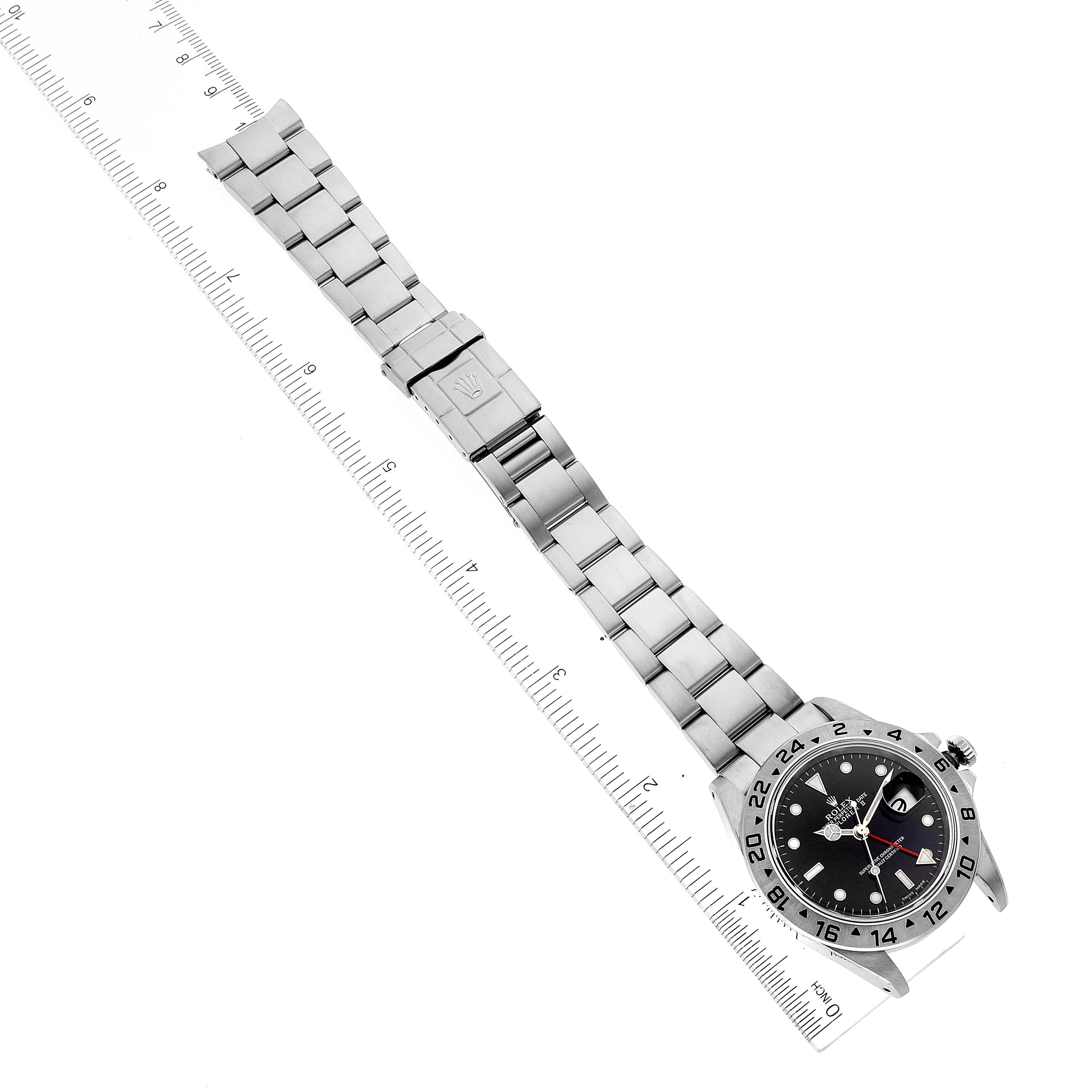 The image shows a top-down view of a Rolex Explorer 16570 Men's Stainless Steel Black Dial 16570 Men's Stainless Steel Black Dial watch with its stainless steel bracelet and a ruler for scale.