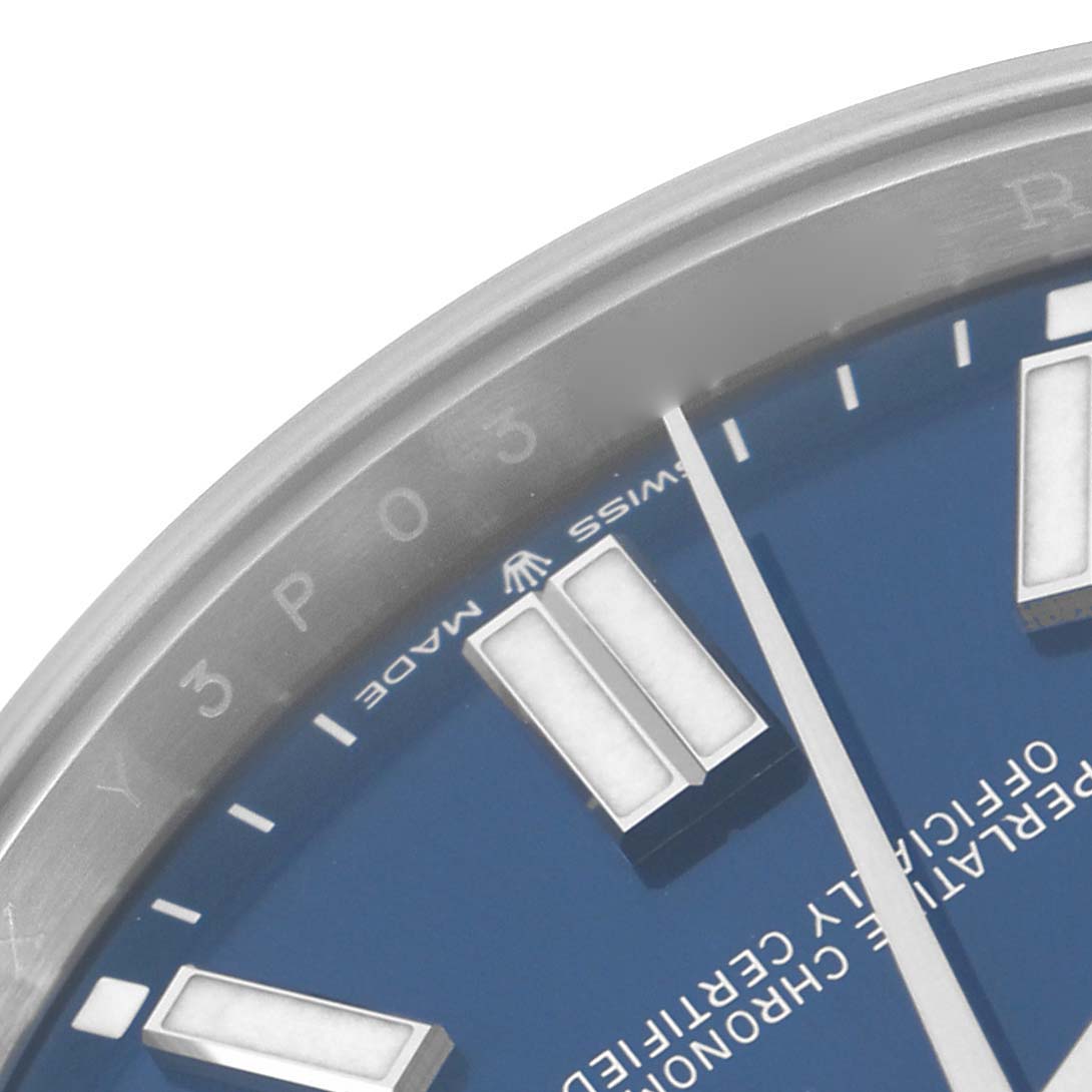 The image shows a close-up of the dial and bezel of a Rolex Oyster Perpetual 124300 Men's Stainless Steel Blue Dial 124300 Men's Stainless Steel Blue Dial, highlighting the blue face and hour markers.