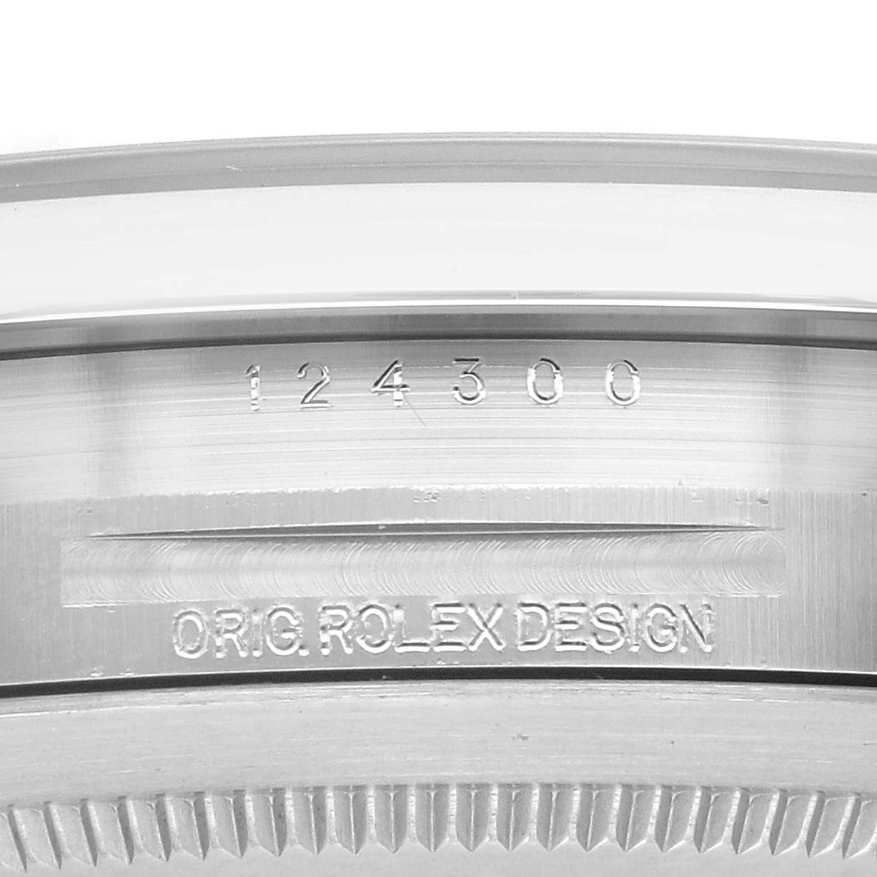 The image shows a close-up of the side case of the Rolex Oyster Perpetual 124300 Men's Stainless Steel Blue Dial 124300 Men's Stainless Steel Blue Dial, highlighting the model number and "ORIG ROLEX DESIGN" engraving.