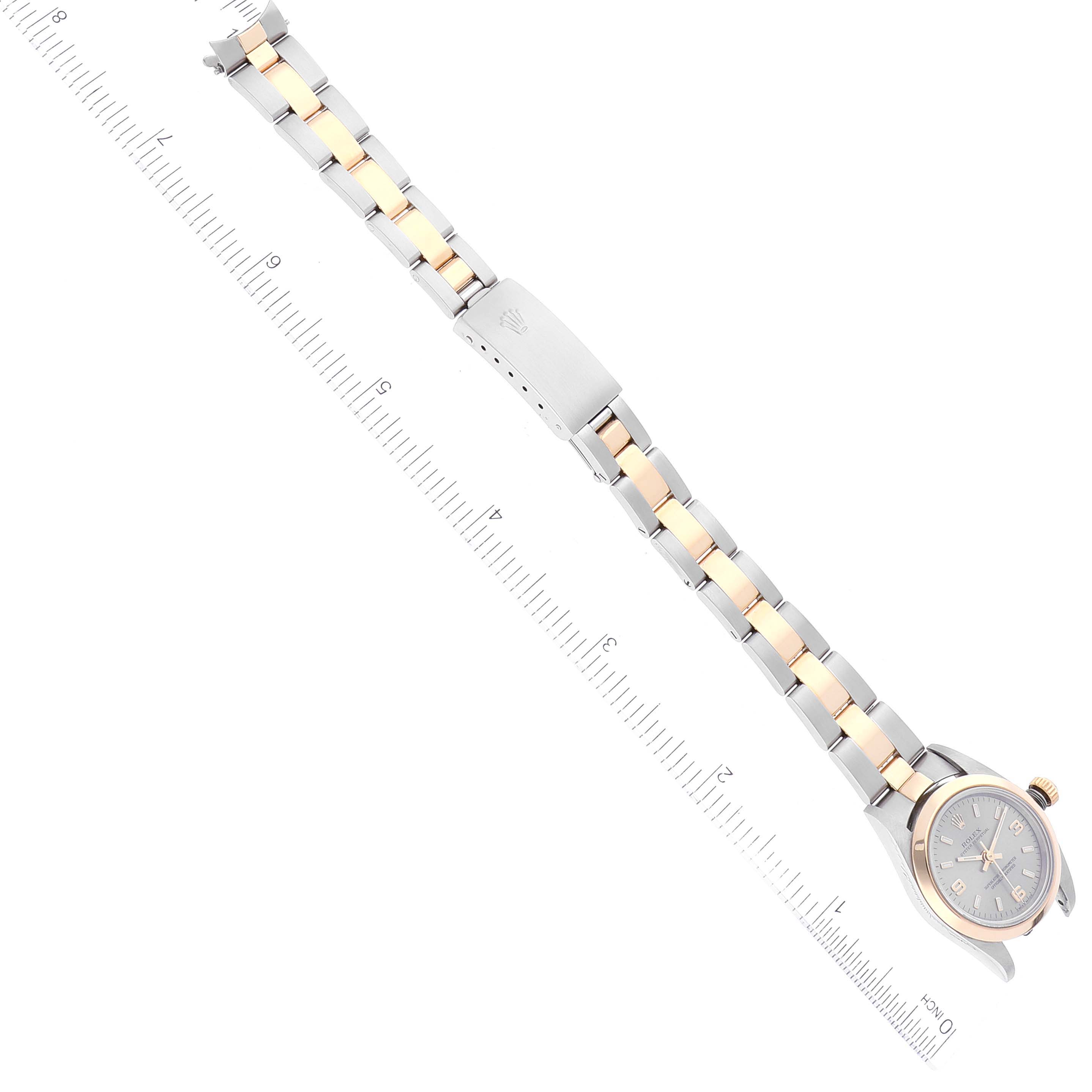 This image shows the Rolex Oyster Perpetual 76183 Women's Steel and Gold (two tone) Grey Dial 76183 Women's Steel and Gold (two tone) Grey Dial watch laid flat with a ruler for scale, highlighting the watch face and bracelet.
