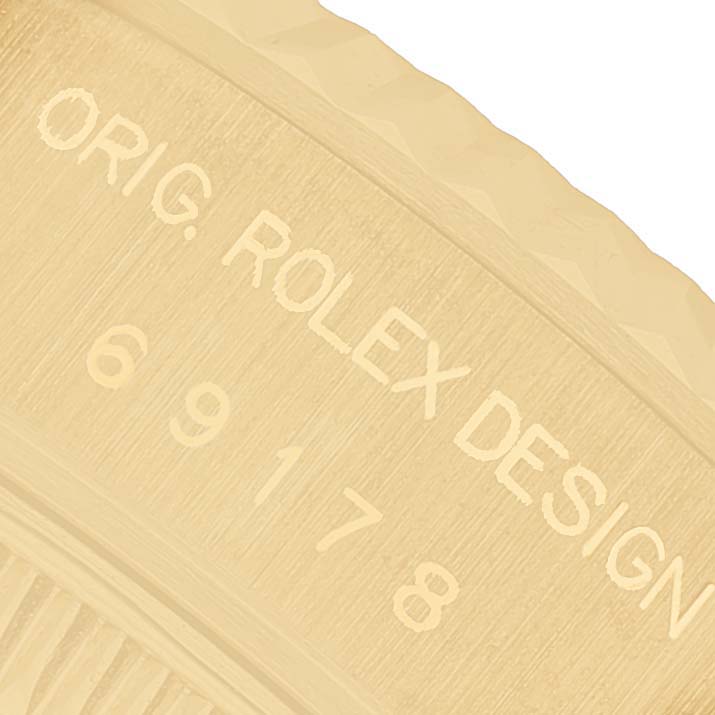 The image shows a close-up of the engraved side of a Rolex President 69178 Women's Yellow Gold Champagne Dial watch, showcasing "ORIG. ROLEX DESIGN 69178".