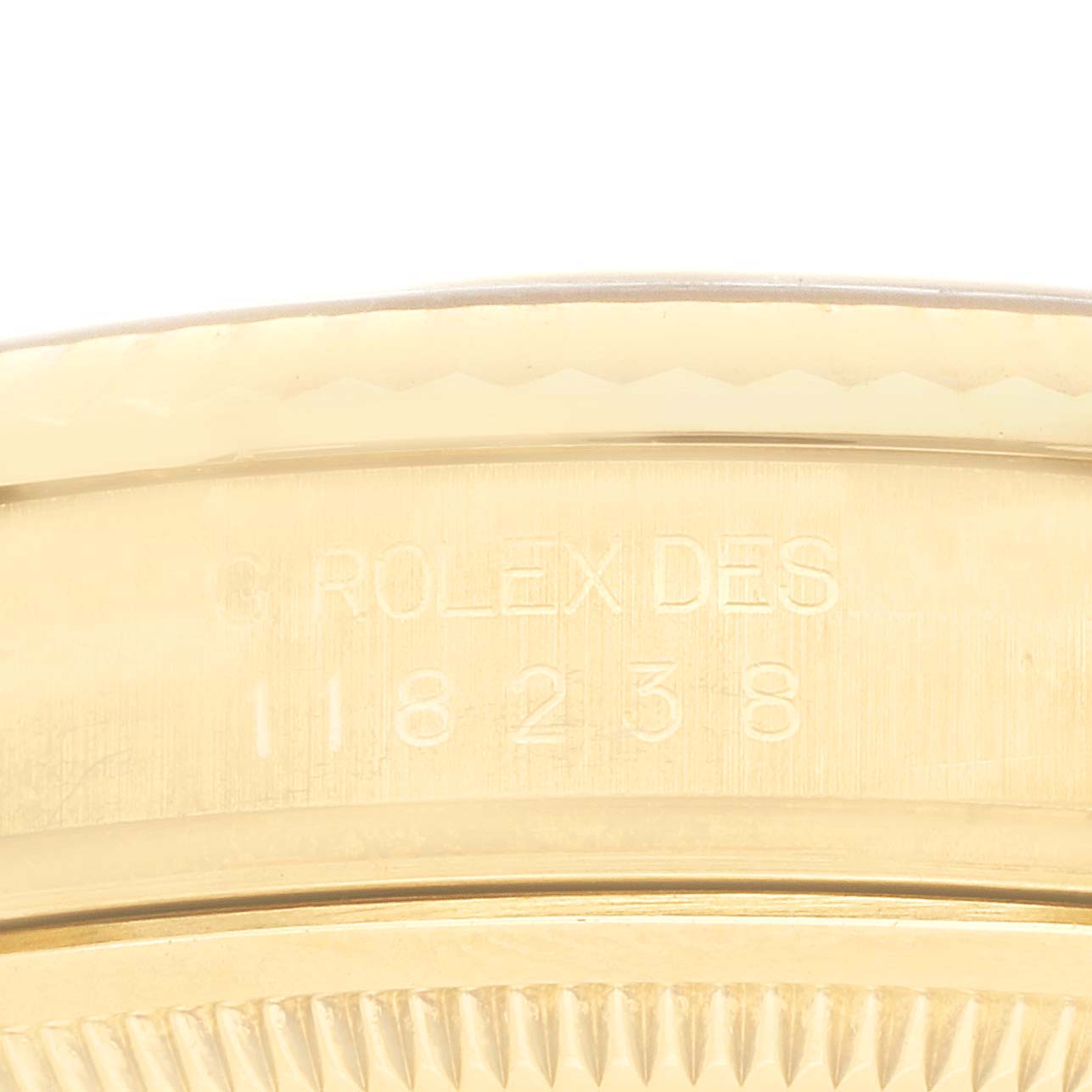 The image shows a close-up of the side of a Rolex President 118238 Men's Yellow Gold Champagne Dial 118238 Men's Yellow Gold Champagne Dial, highlighting the engraved case details.