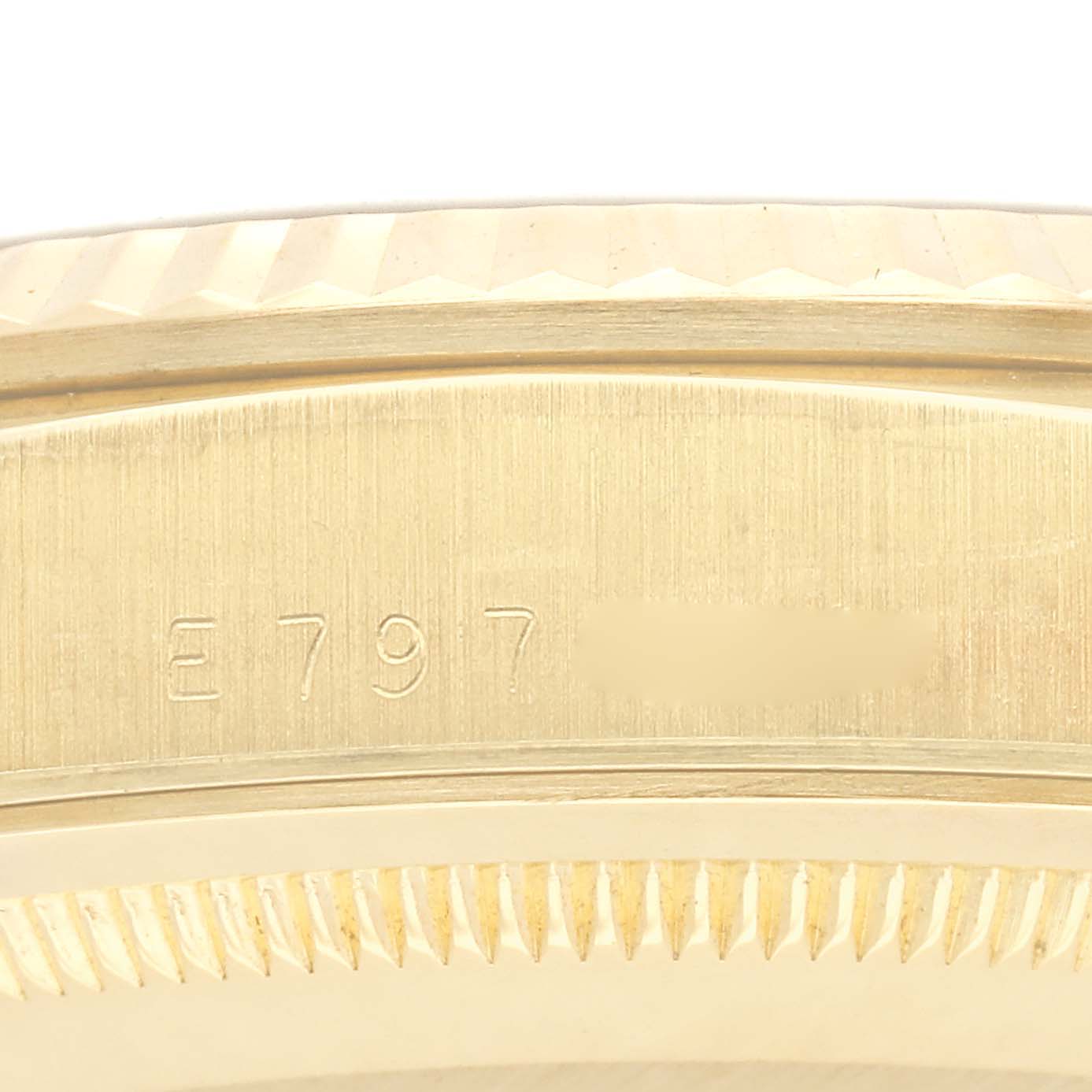 The image shows a close-up of the side of a Rolex President 18238 Men
s Yellow Gold Champagne Dial 18238 Men
s Yellow Gold Champagne Dial watch, highlighting the serial number and the scalloped bezel edge.