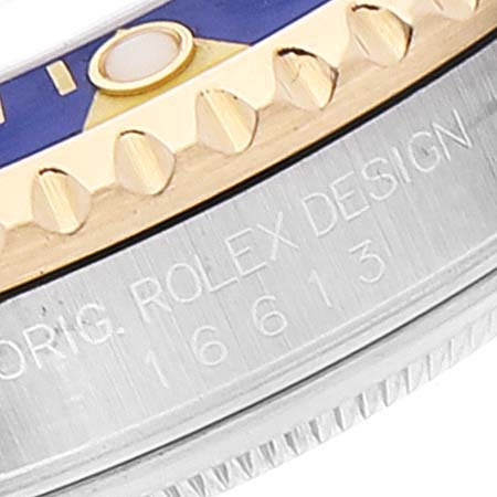 The image shows a close-up of the side of a Rolex Submariner 16613 Men
s Steel and Gold (two tone) Blue Dial 16613 Men
s Steel and Gold (two tone) Blue Dial model, highlighting the bezel and engraved case details.