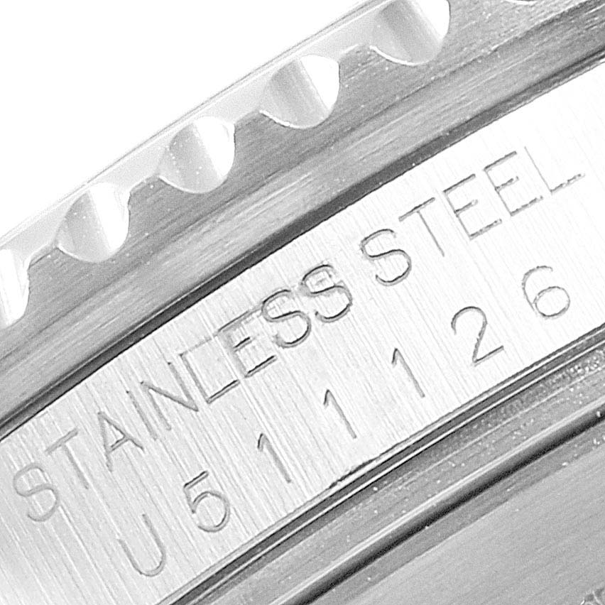 Close-up of the stainless steel case edge and bezel teeth of the Rolex Submariner 16610 Men
s Stainless Steel Black Dial 16610 Men
s Stainless Steel Black Dial watch, showing engraved text.