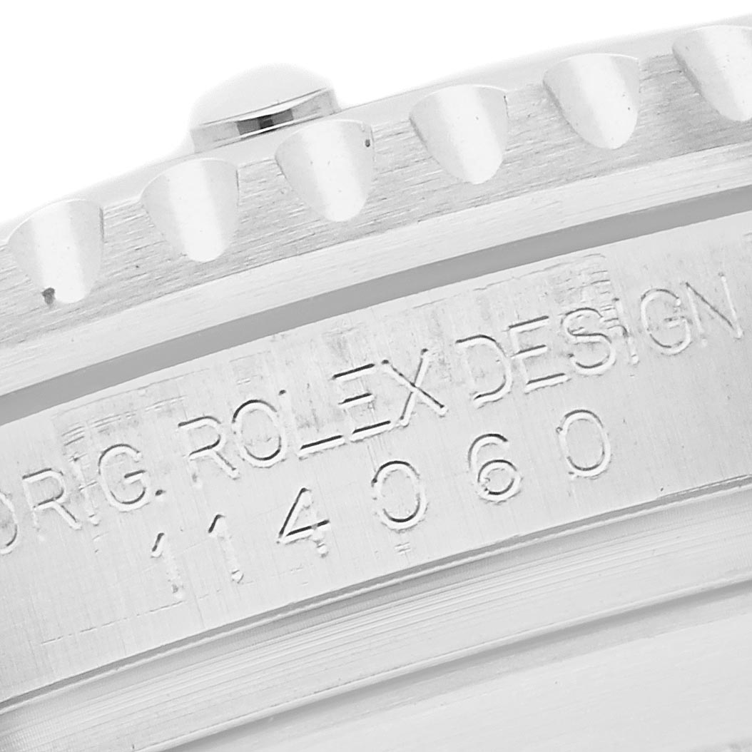 The image shows a close-up of the Rolex Submariner 114060 Men's Stainless Steel Black Dial 114060 Men's Stainless Steel Black Dial's side, highlighting the engraved "ORIG. ROLEX DESIGN" and model number.