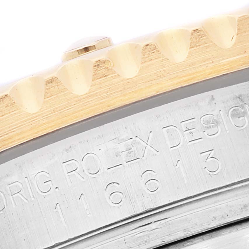 This close-up image of a Rolex Submariner 116613 Men's Steel and Gold (two tone) Blue Dial 116613 Men's Steel and Gold (two tone) Blue Dial watch shows a detailed view of the bezel and case side engraving.