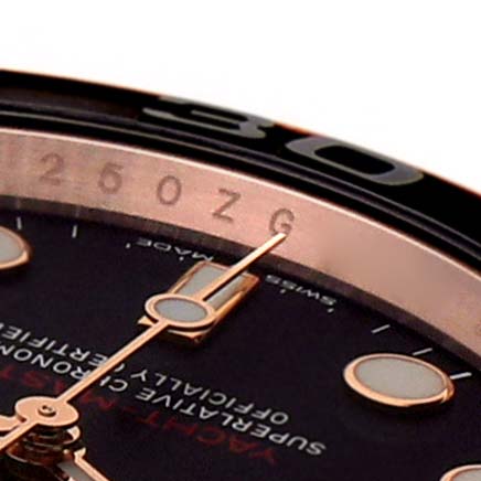 This close-up image shows part of the dial and bezel of a Rolex Yacht-Master 126655 Men's Rose Gold Black Dial 126655 Men's Rose Gold Black Dial watch, including the hands and hour markers.