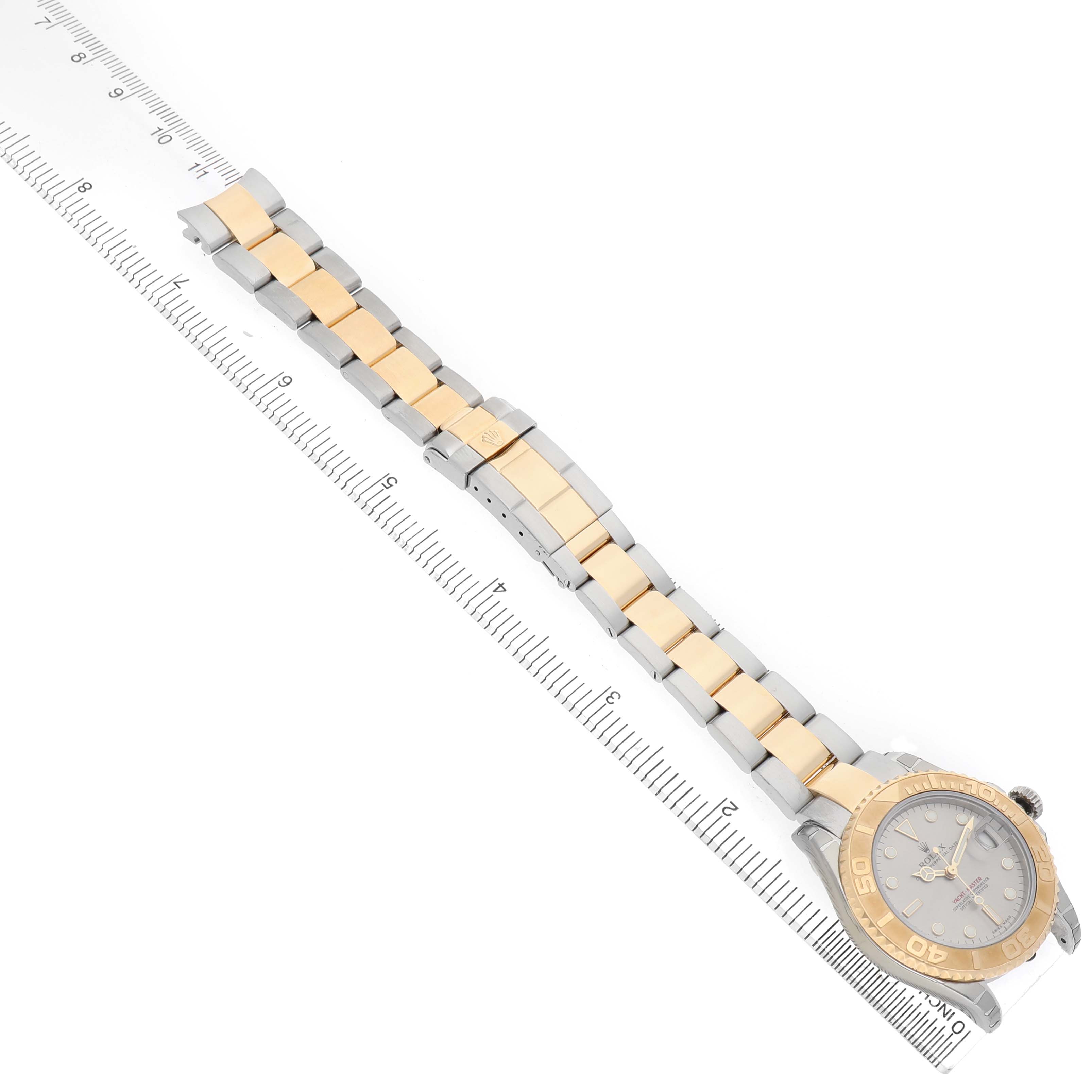 The image shows a Rolex Yacht-Master 168623 Men's Steel and Gold (two tone) Grey Dial watch at an oblique angle, displaying the face, bezel, and two-tone bracelet alongside a ruler.