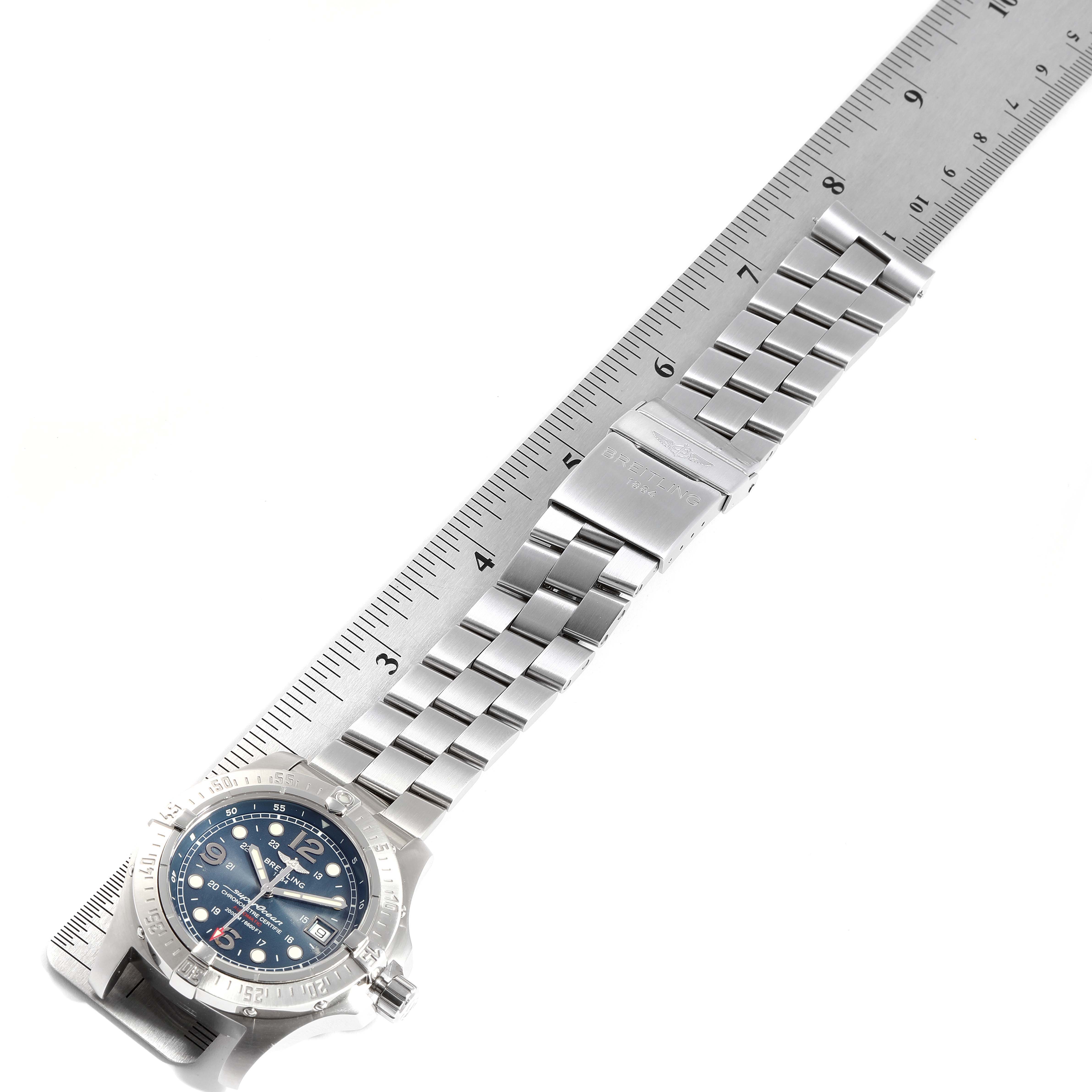 The image shows a top view of a Breitling Superocean A17390 Men
s Stainless Steel Blue Dial A17390 Men
s Stainless Steel Blue Dial watch with its metal bracelet measured against a ruler.