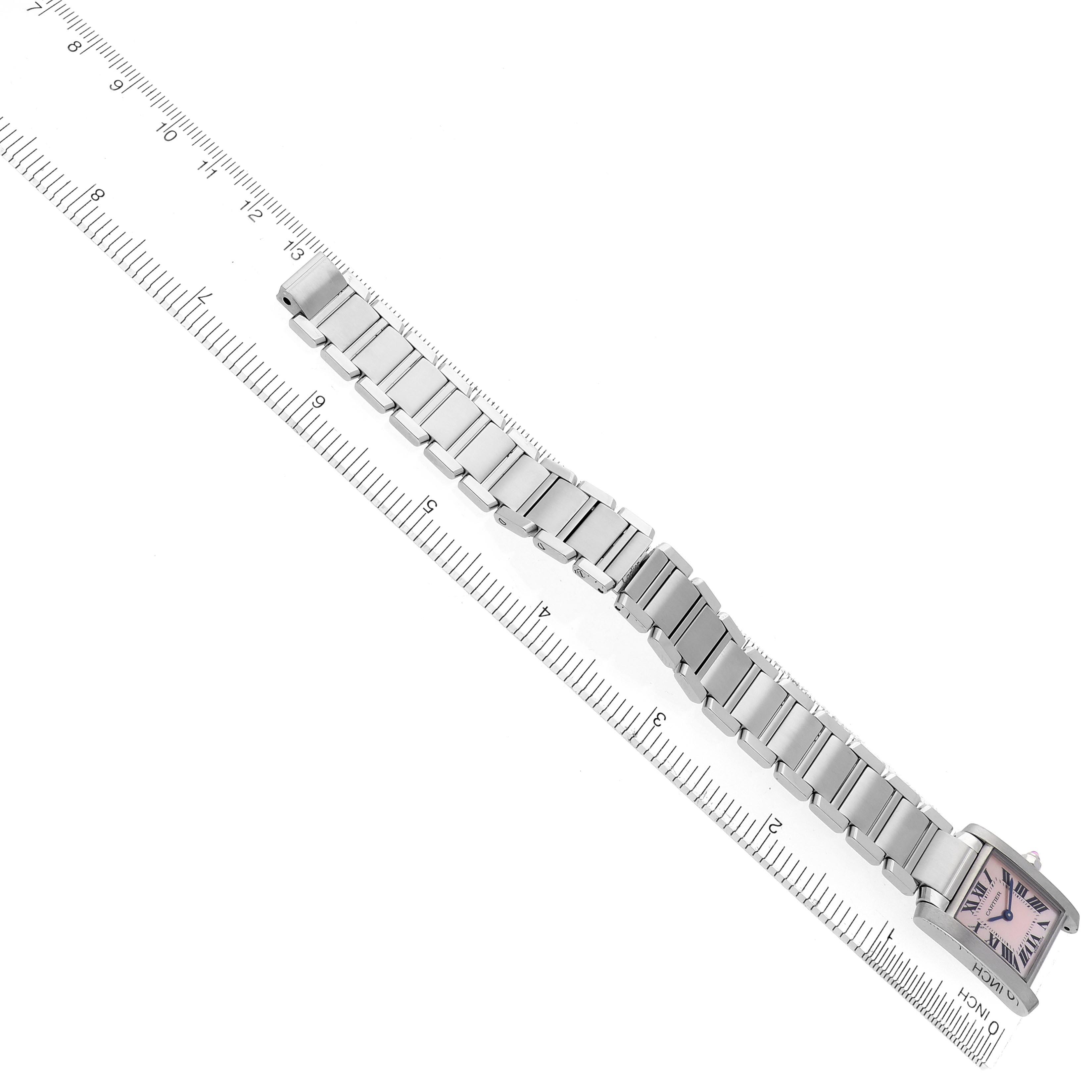 The Cartier Tank Française watch is shown in a top-down view, displaying the face and full metal bracelet alongside a ruler.
