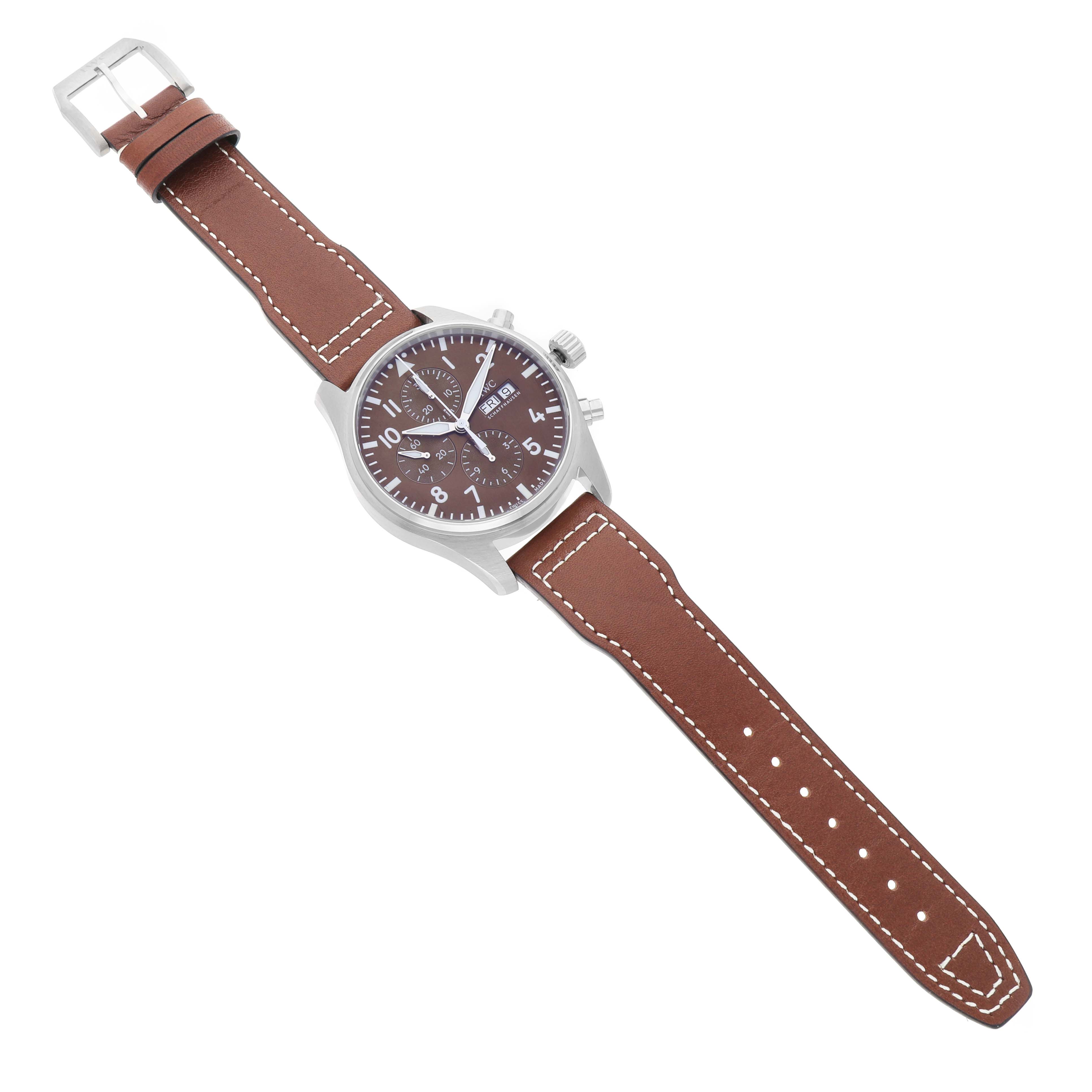 The IWC Pilot IW377713 Men's Stainless Steel Brown Dial model watch is shown from a top-down angle, displaying the dial, case, crown, and full leather strap.