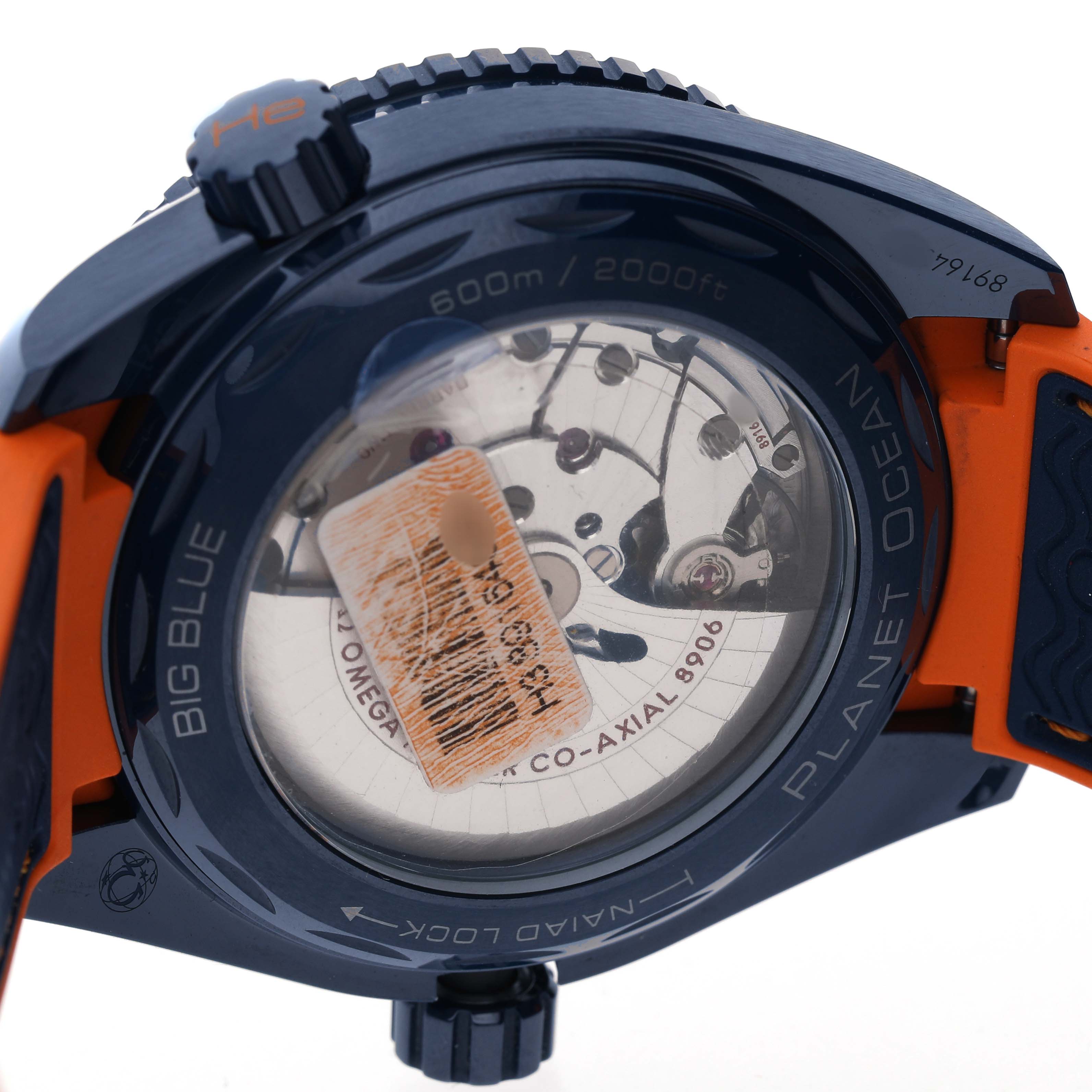 The image shows the back view of an Omega Planet Ocean 215.92.46.22.03.001 Men's Ceramic Blue Dial watch, highlighting the transparent case back and the movement inside.