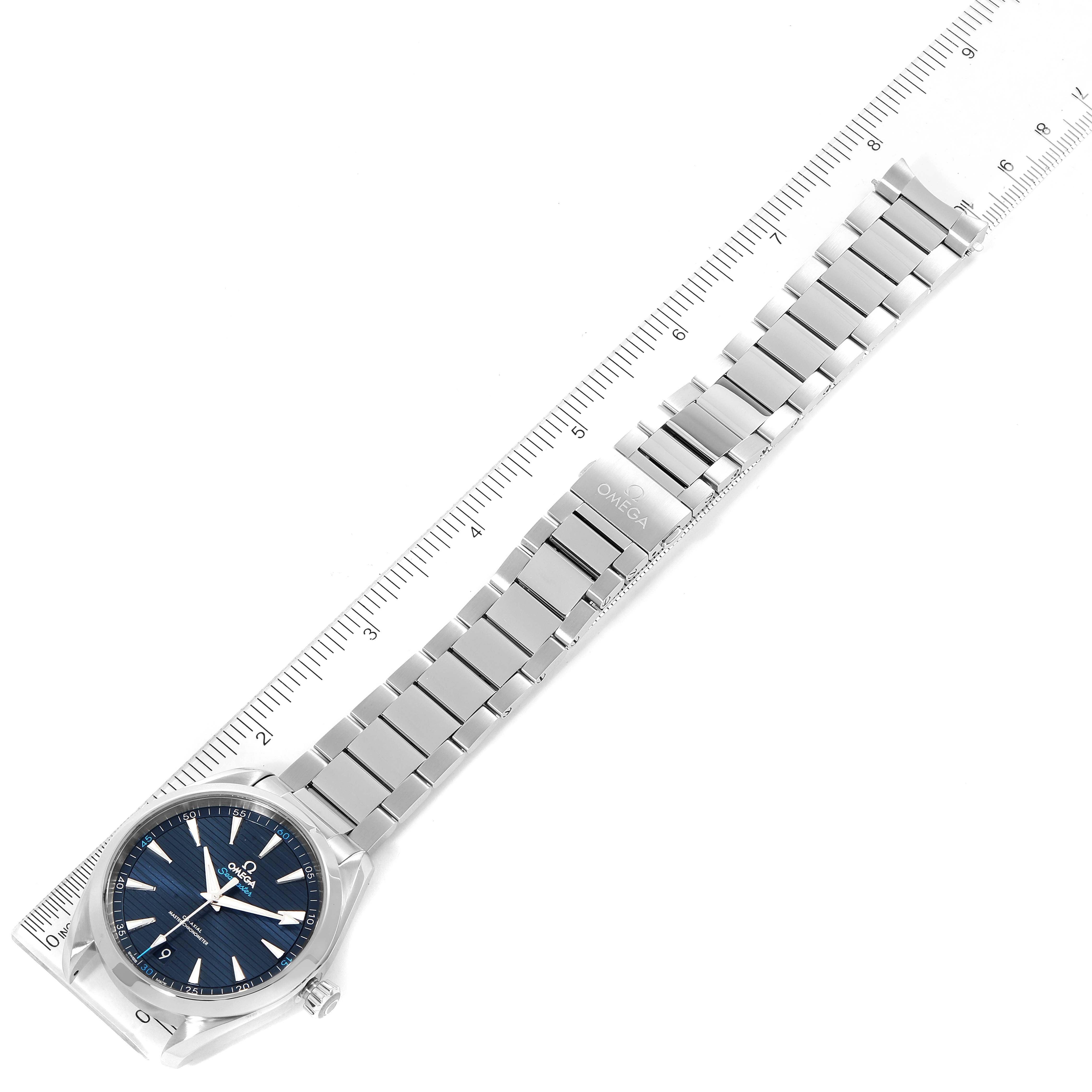 The image shows an Omega Aqua Terra 220.10.41.21.03.001 Men's Stainless Steel Blue Dial 220.10.41.21.03.001 Men's Stainless Steel Blue Dial watch laid flat, highlighting the face, bracelet, and clasp, with a ruler for scale.