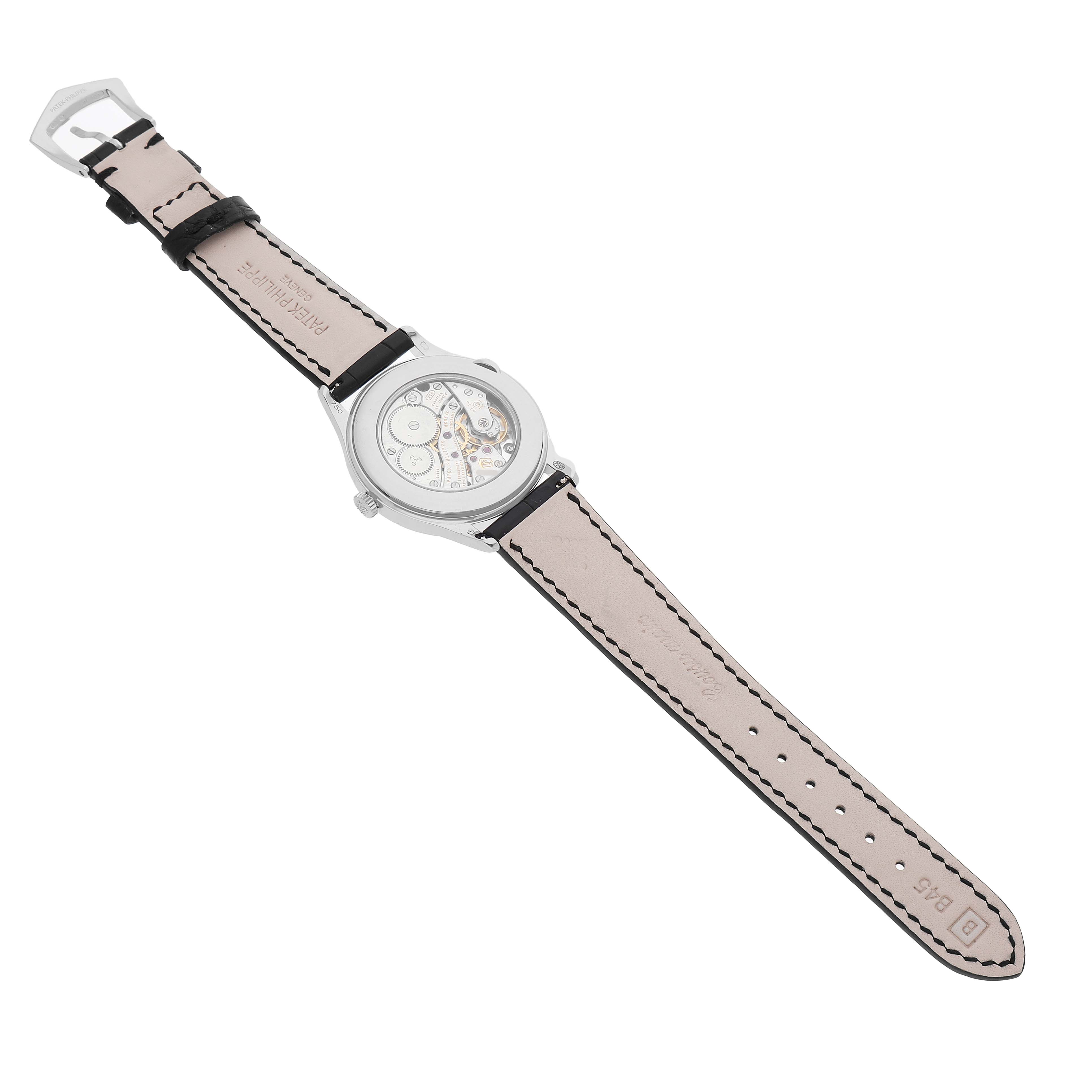 The Patek Philippe Calatrava 4897G Women's White Gold Blue Dial watch is shown from the back, displaying the movement and a light-colored leather strap.