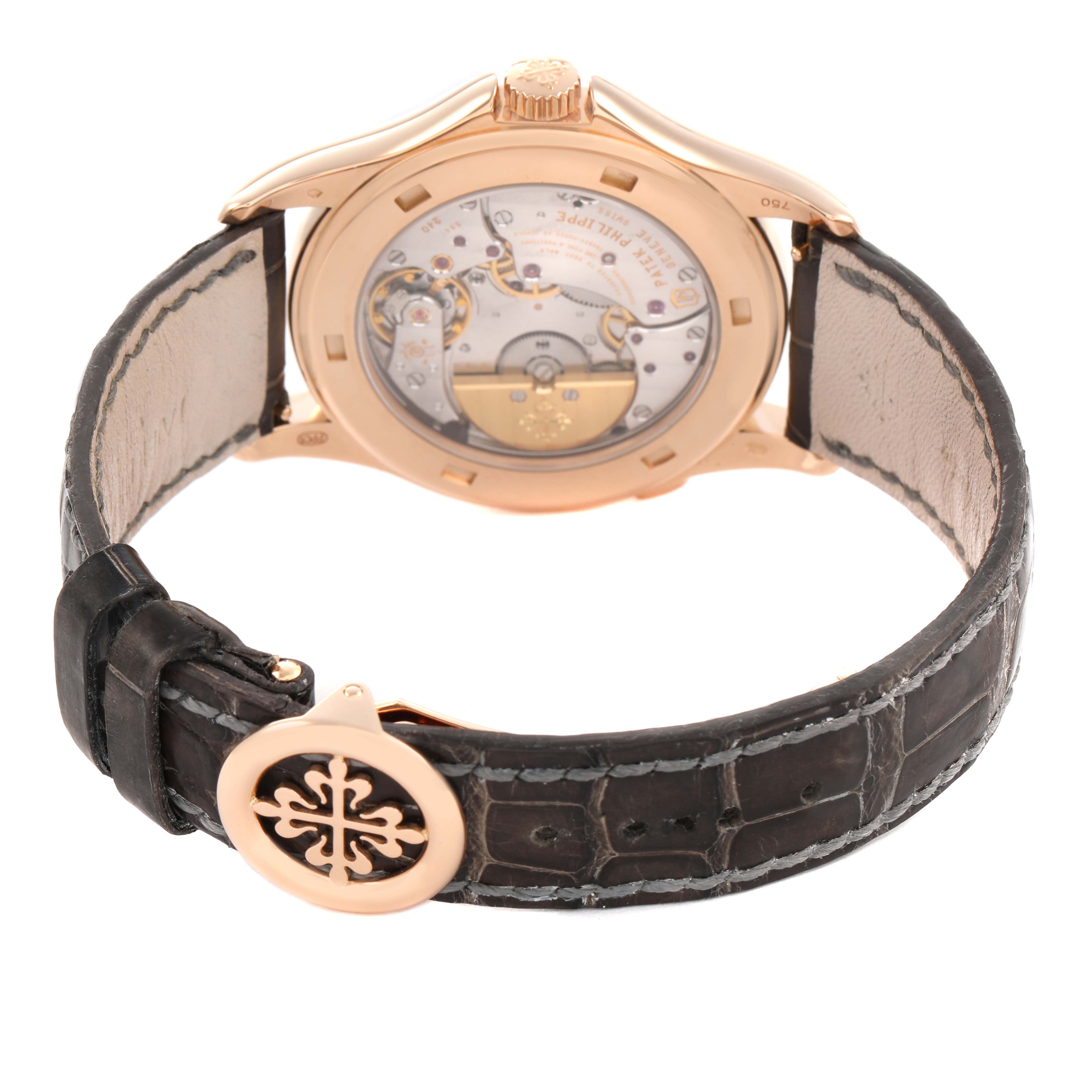 The Patek Philippe Complications 5130R Men's Rose Gold Silver Dial watch is shown from the back, displaying its movement and leather strap with a decorative clasp.
