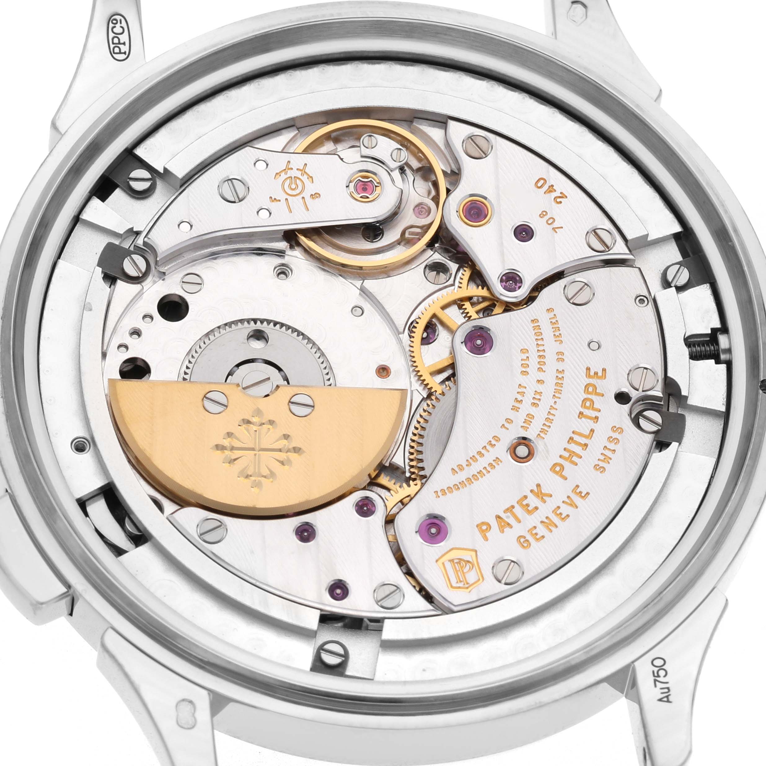 The image shows the movement of a Patek Philippe Complications 5230G Men's White Gold Grey Dial watch from the rear, highlighting gears, engravings, and a gold rotor.