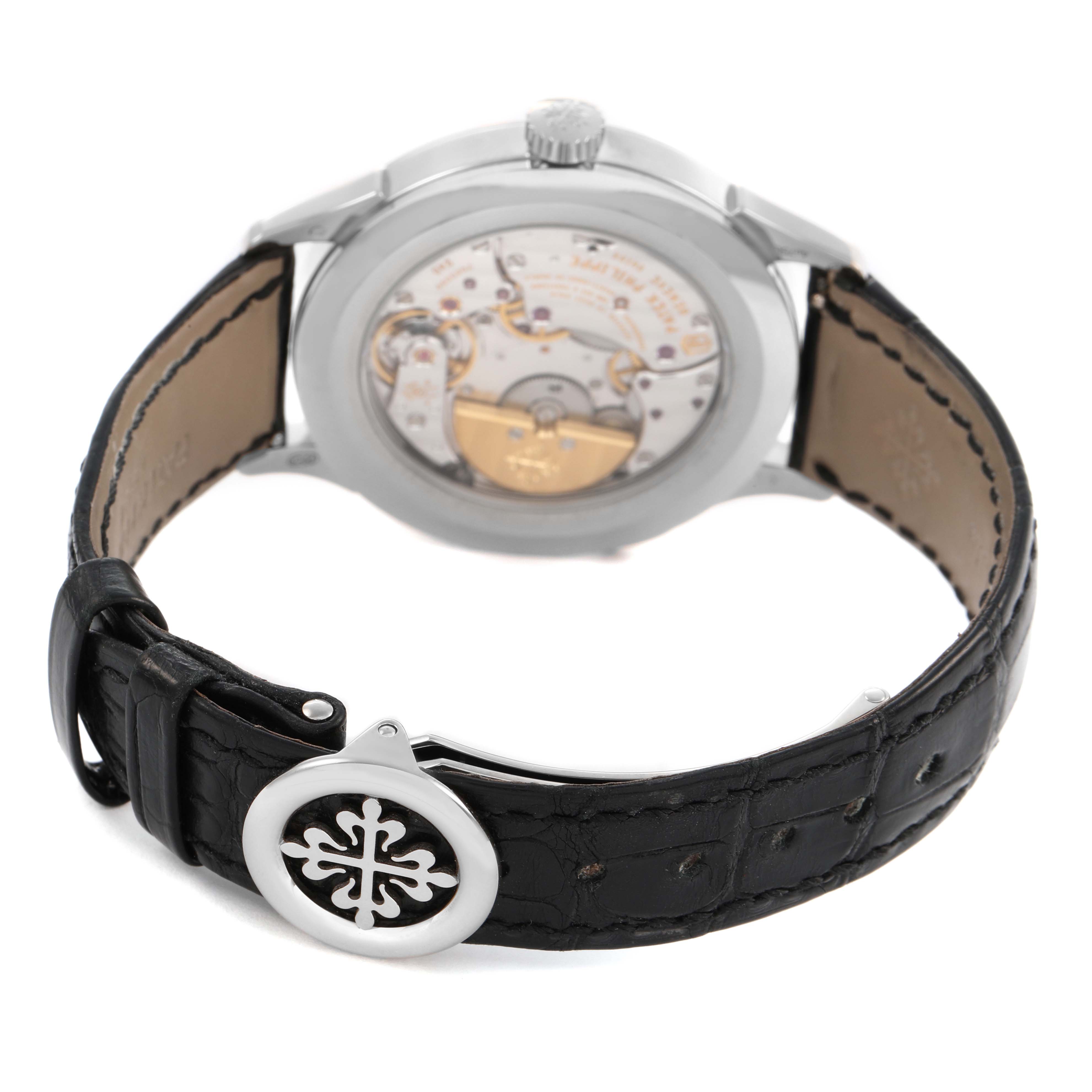 The image shows the back of a Patek Philippe Complications 5230G Men's White Gold Grey Dial watch, highlighting the movement and leather strap with buckle.