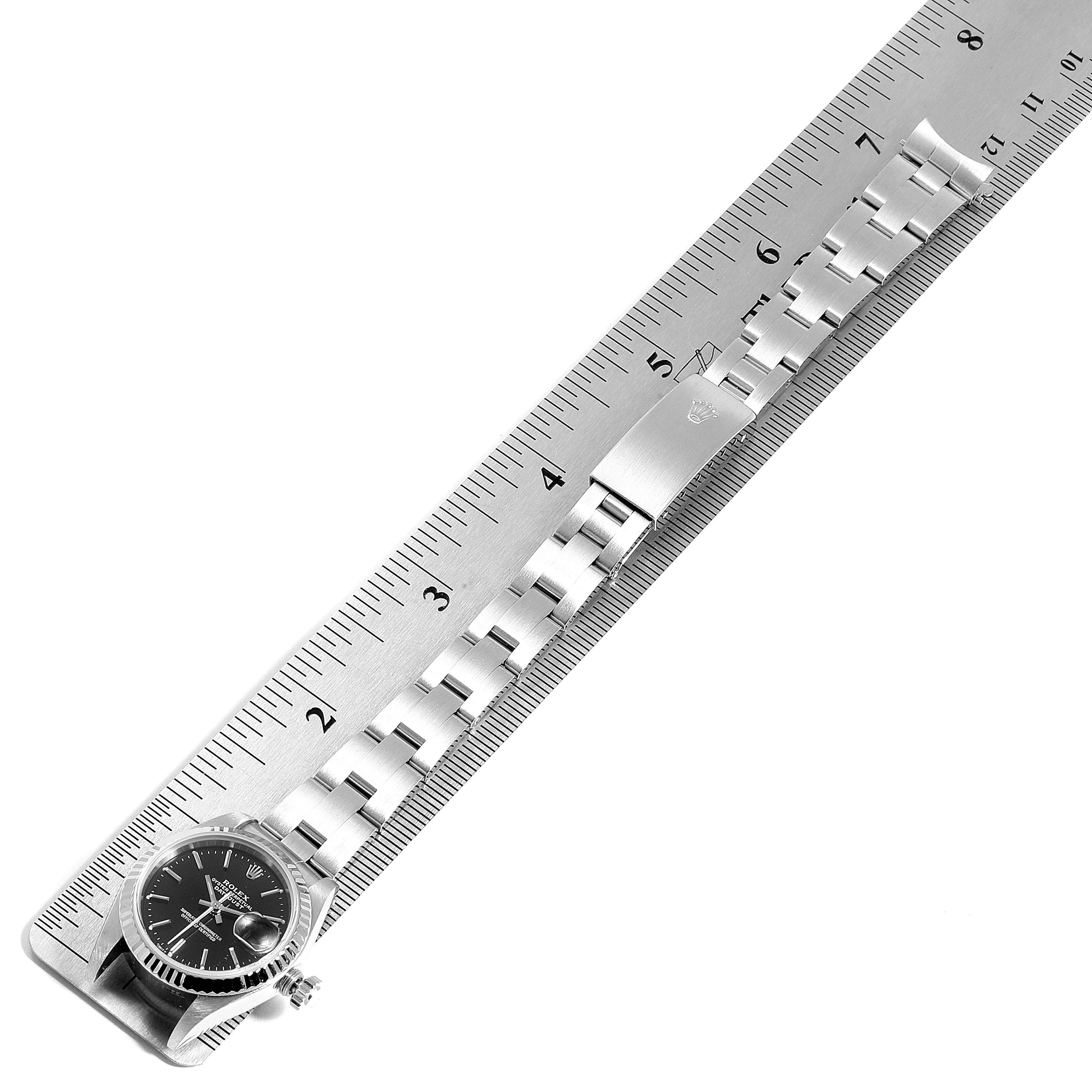 This image shows a side view of a Rolex Datejust 79174 Women's Stainless Steel Black Dial 79174 Women's Stainless Steel Black Dial watch with its bracelet on top of a ruler for measurement.