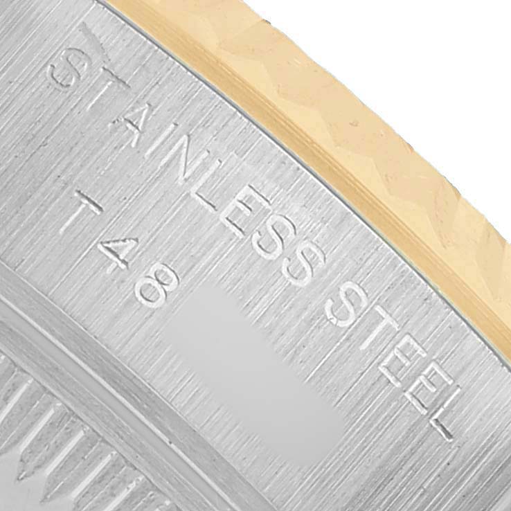 The image shows a close-up of the edge of a Rolex Datejust 69173 Women's Steel and Gold (two tone) Champagne Dial with "STAINLESS STEEL" engraved.