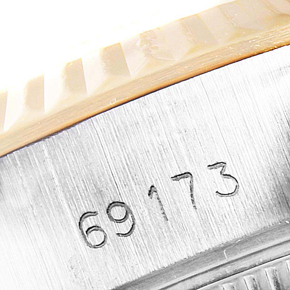 This close-up image shows the watch case and part of the fluted bezel of a Rolex Datejust 69173 Women's Stainless Steel Champagne Dial 69173 Women's Stainless Steel Champagne Dial model, along with its serial number.