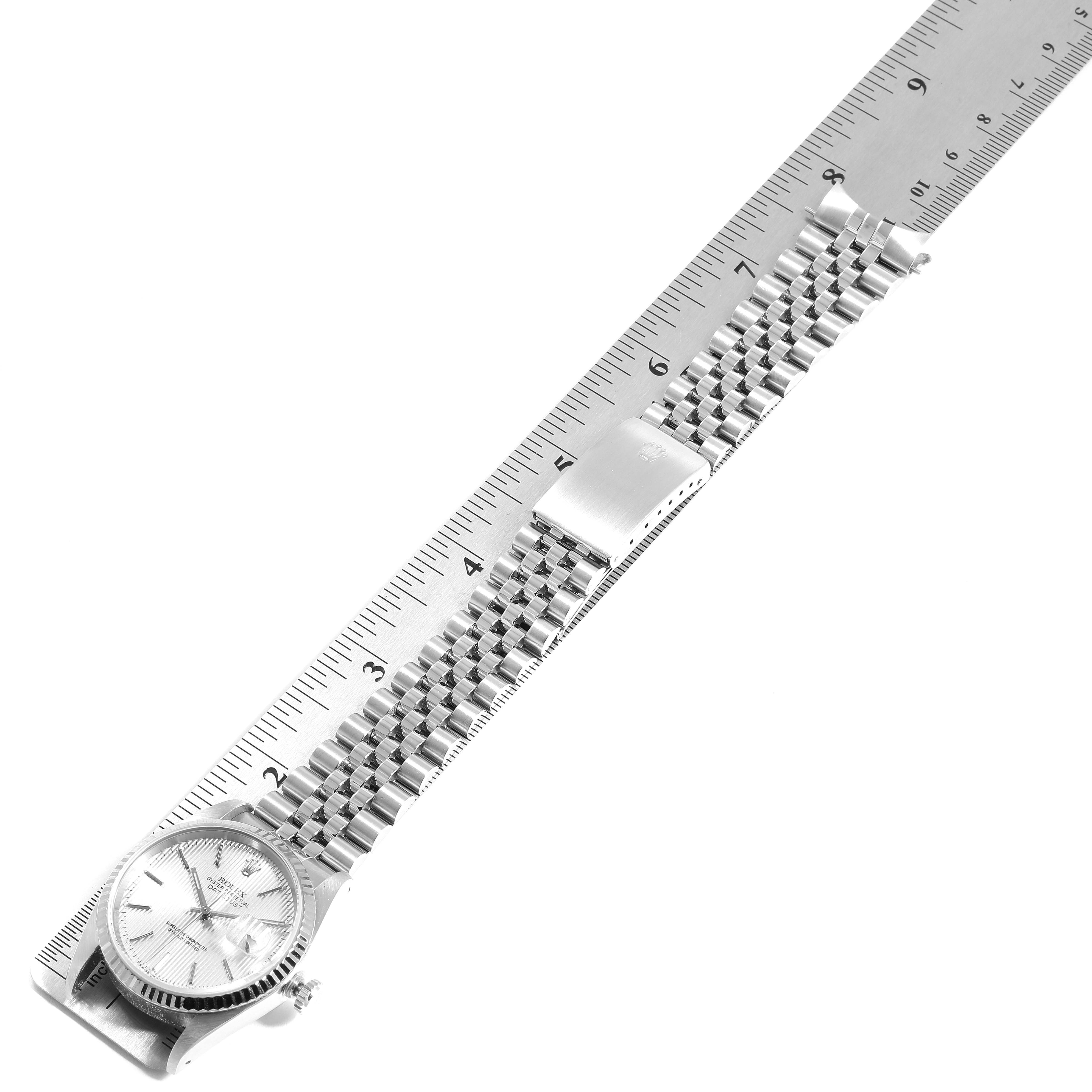 The Rolex Datejust 16234 Men's Stainless Steel Silver Dial 16234 Men's Stainless Steel Silver Dial watch is shown from a top-down angle alongside a ruler, displaying the face, bezel, and bracelet.