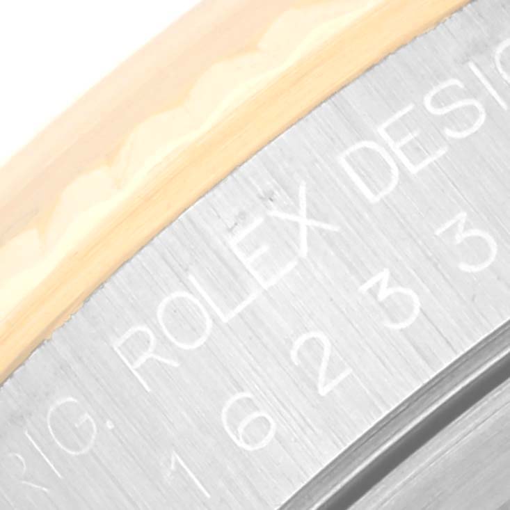 This close-up image shows the engraved text "ROLEX DESIGN" on the case side of a Rolex Datejust 16233 Men's Steel and Gold (two tone) White Dial 16233 Men's Steel and Gold (two tone) White Dial watch.