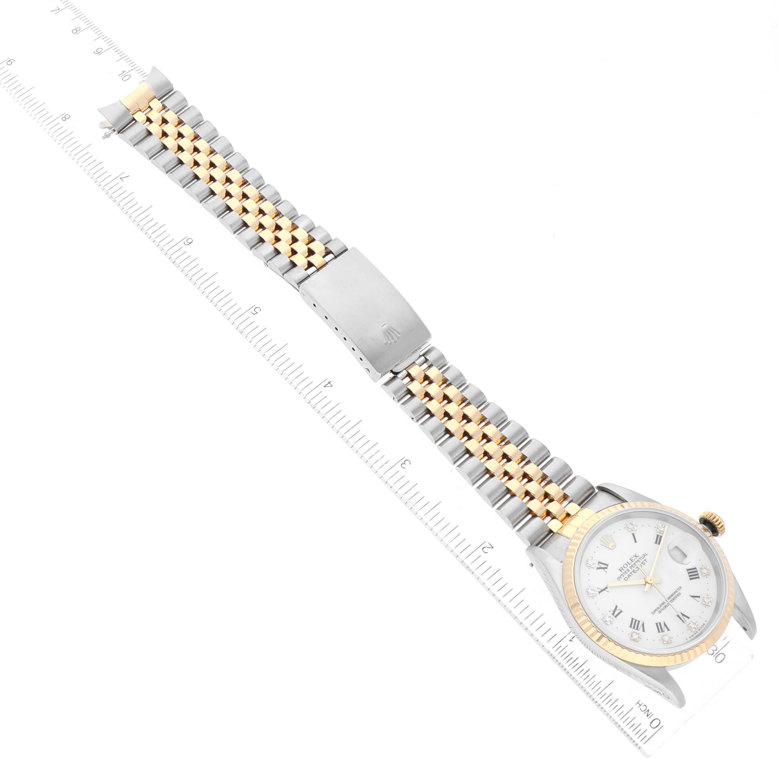The image shows a Rolex Datejust 16233 Men's Steel and Gold (two tone) White Dial 16233 Men's Steel and Gold (two tone) White Dial watch from a top-down angle, fully displaying the watch face, bezel, and dual-tone bracelet against a ruler.