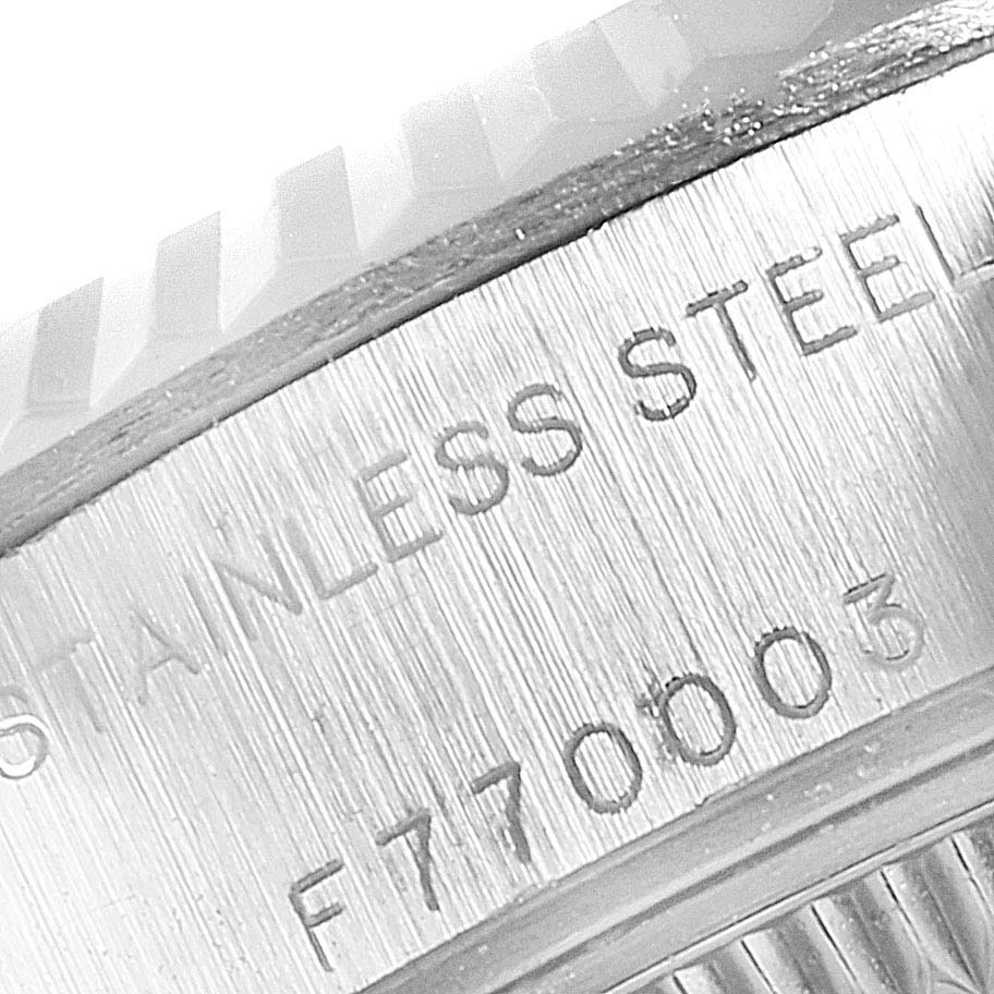 The image shows a close-up of the case
s side of a Rolex Datejust 79174 Women
s Stainless Steel Black Dial 79174 Women
s Stainless Steel Black Dial, highlighting the "STAINLESS STEEL" engraving and the serial number.