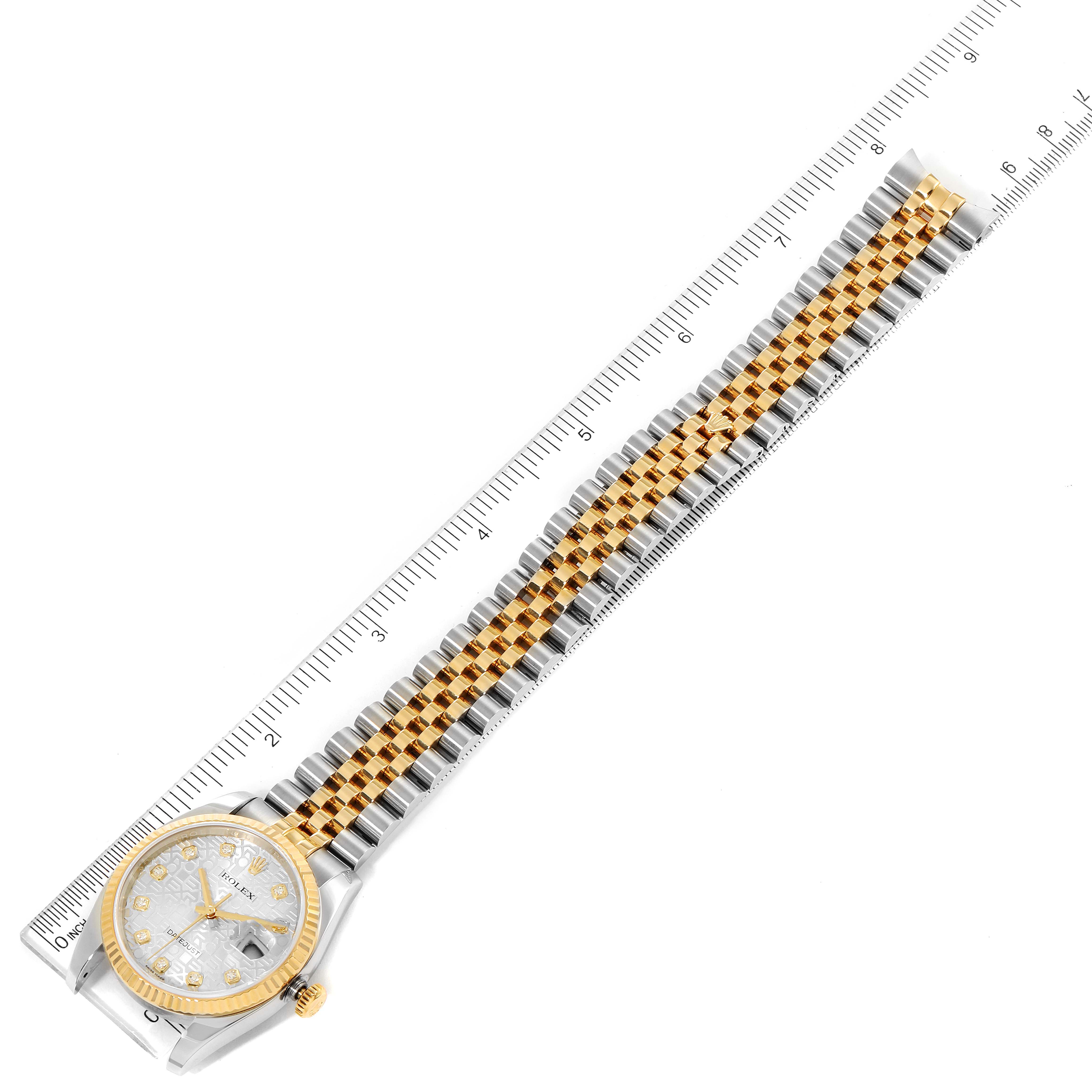 The Rolex Datejust 116233 Men's Steel and Gold (two tone) Silver Dial 116233 Men's Steel and Gold (two tone) Silver Dial watch is shown from a top view, displaying the face and the entire bracelet aligned with a ruler.