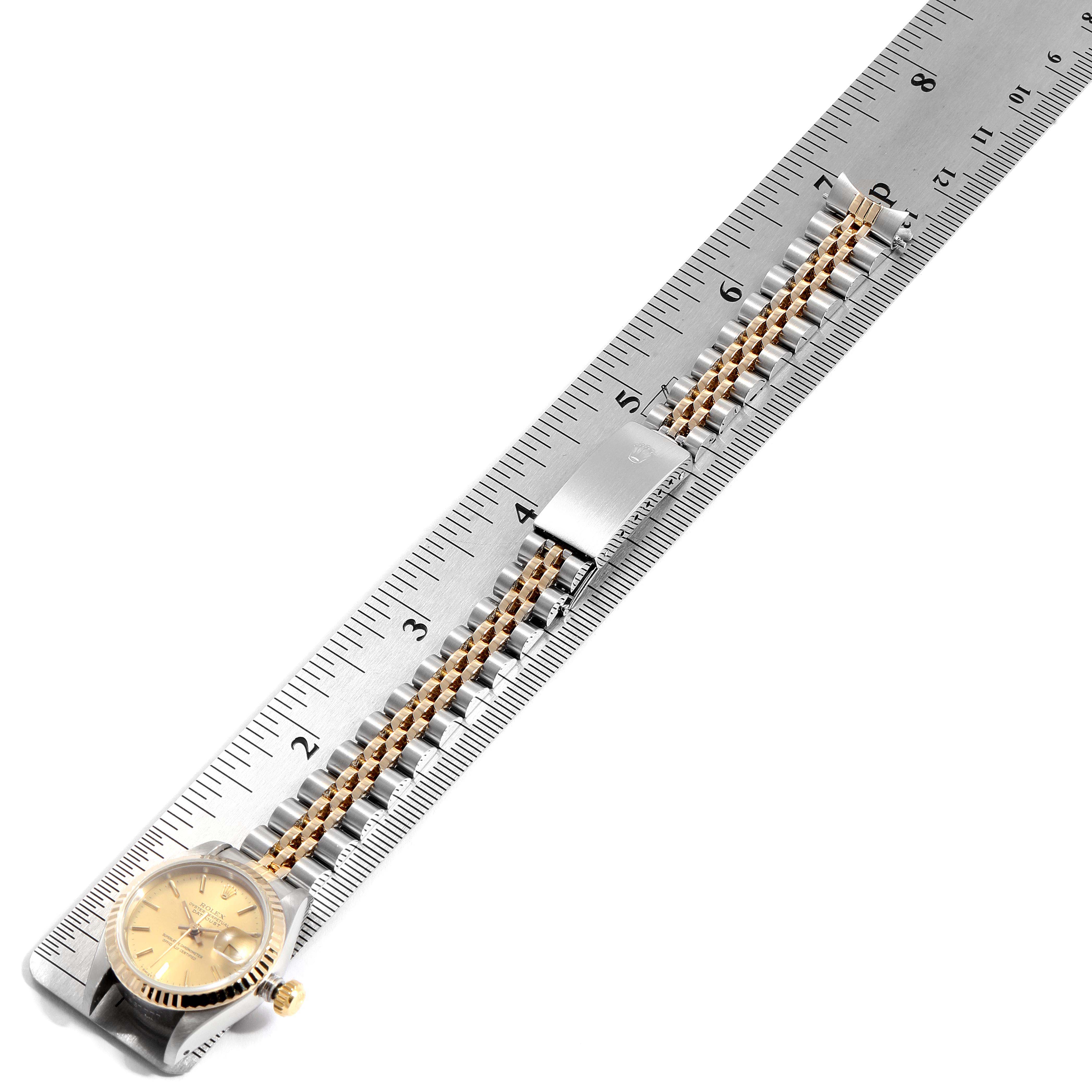 This Datejust Rolex watch is shown from a top-down angle, displaying the face, bezel, and entire bracelet along with a ruler for scale.