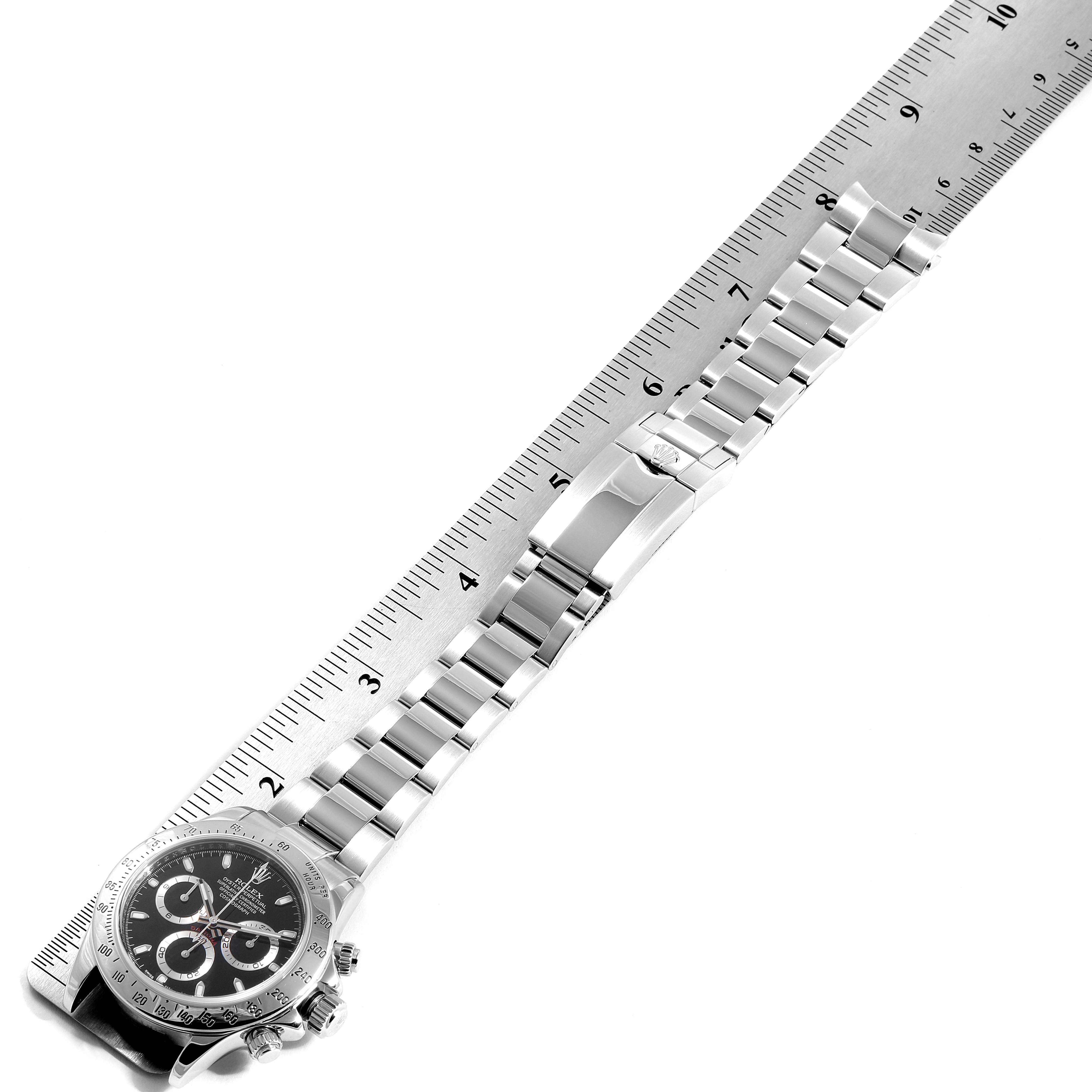 The image shows a Rolex Daytona 116520 Men's Stainless Steel Black Dial 116520 Men's Stainless Steel Black Dial watch laid flat with its full strap length measured by a ruler.