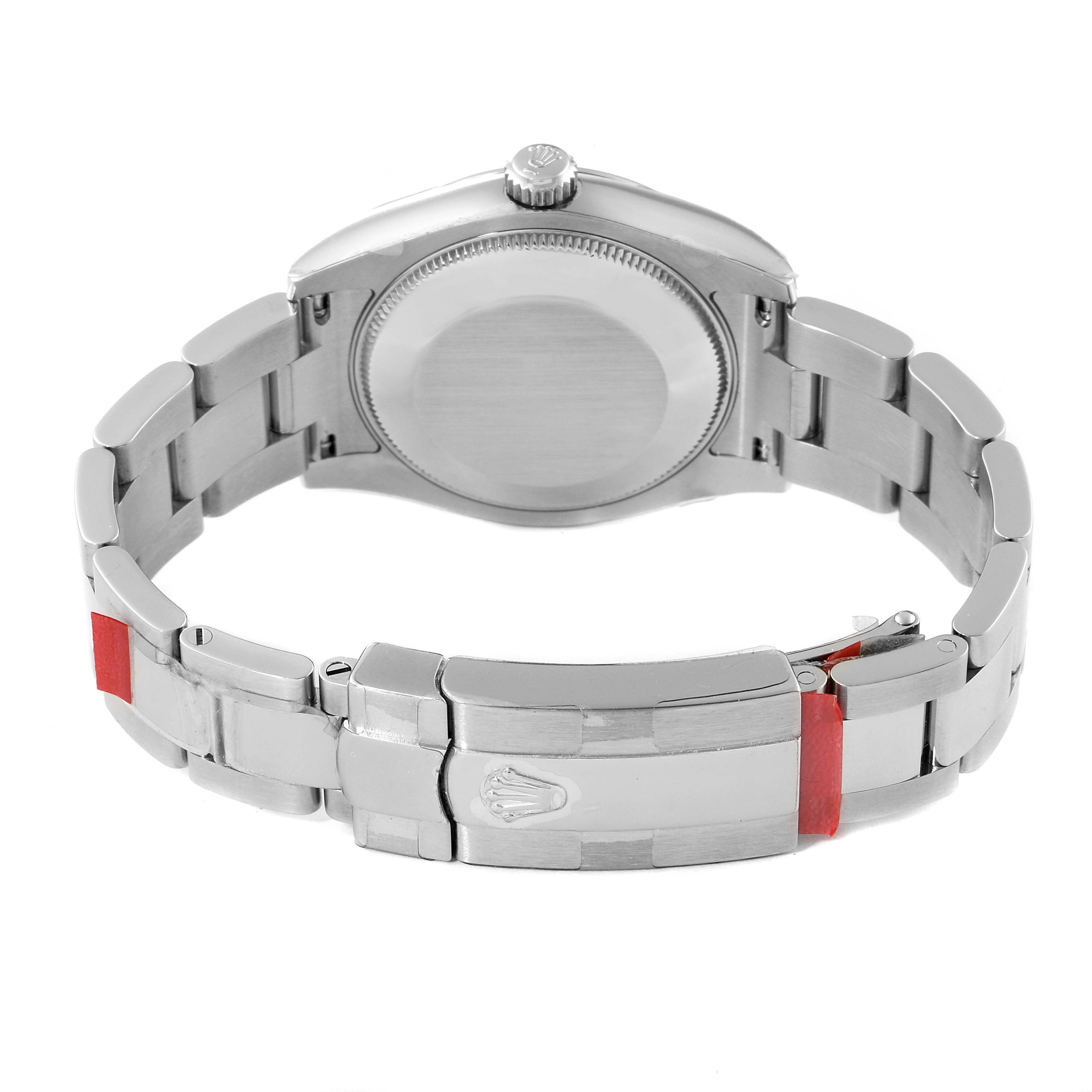 The image shows the back view of a Mid-Size Rolex watch, highlighting its case, crown, and metal bracelet with the clasp.