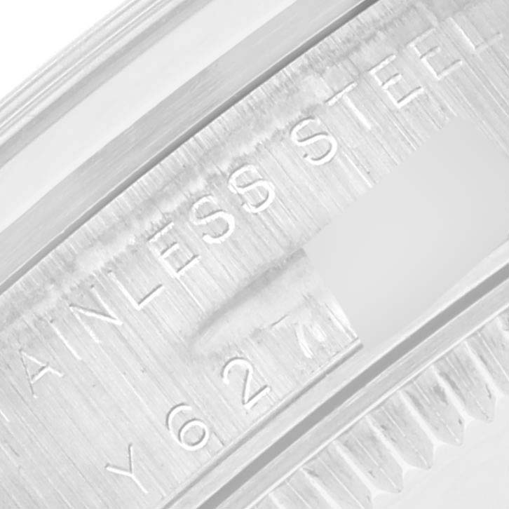 This close-up image shows the engraved 'STAINLESS STEEL' and part of the serial number on the bezel of a Rolex Mid-Size 77080 Women's Stainless Steel Orange Dial 77080 Women's Stainless Steel Orange Dial watch.