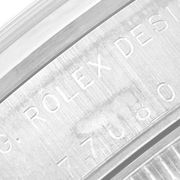 The image shows a close-up of the engraved underside of a Rolex Mid-Size 77080 Women's Stainless Steel Orange Dial 77080 Women's Stainless Steel Orange Dial watch case.