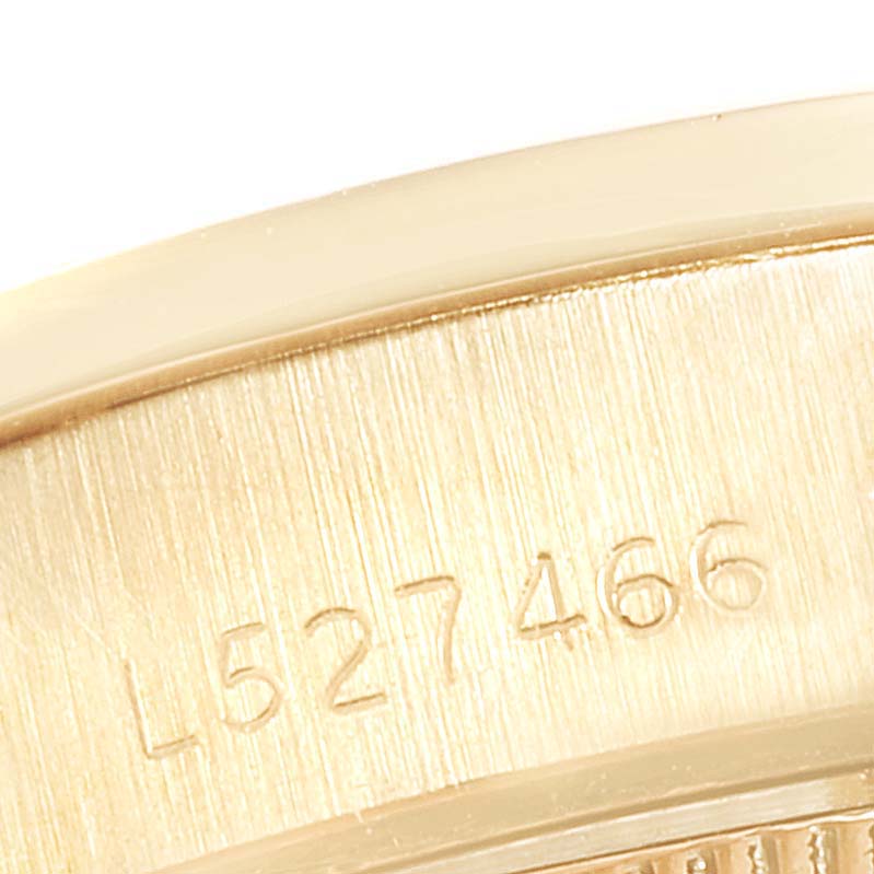 This close-up shows the serial number on the gold case of a Rolex President 69138 Women
s Yellow Gold Champagne Dial 69138 Women
s Yellow Gold Champagne Dial model watch.