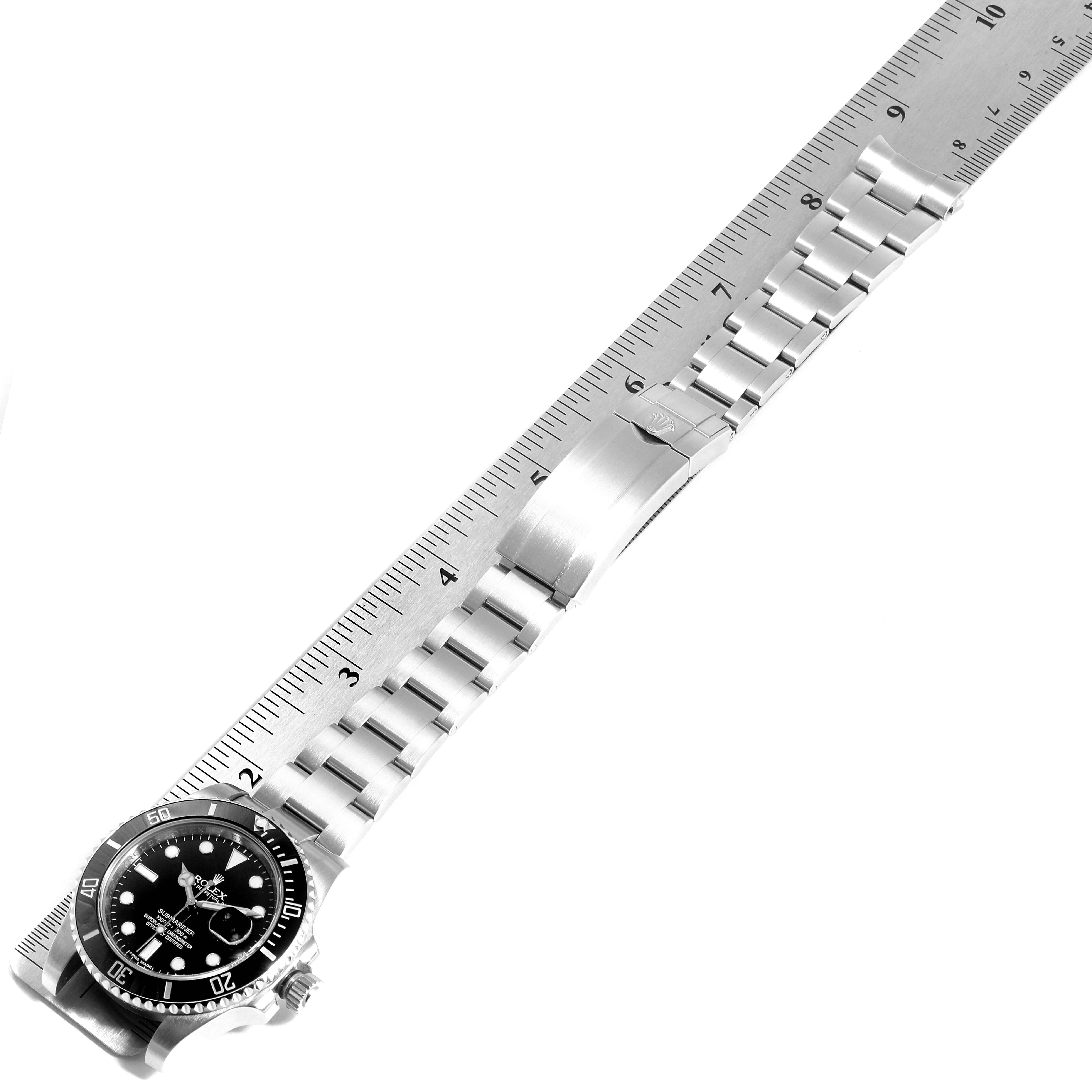The image shows a Rolex Submariner 116610 Men
s Stainless Steel Black Dial 116610 Men
s Stainless Steel Black Dial watch laid flat with a ruler measuring its length, displaying the face, bracelet, and clasp.
