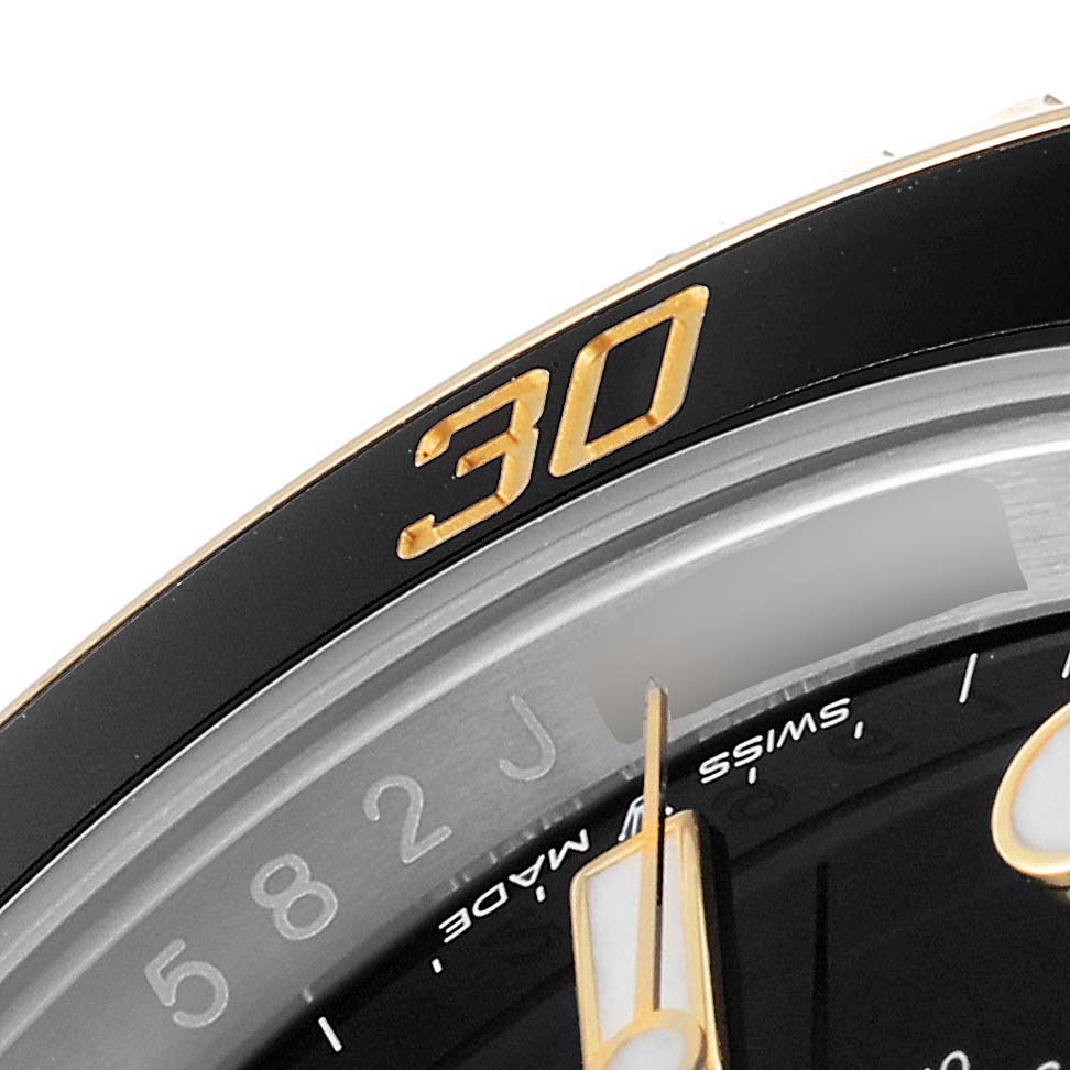 This is a close-up image showing the bezel and part of the dial of a Rolex Submariner 126613 Men
s Steel and Gold (two tone) Black Dial 126613 Men
s Steel and Gold (two tone) Black Dial watch.