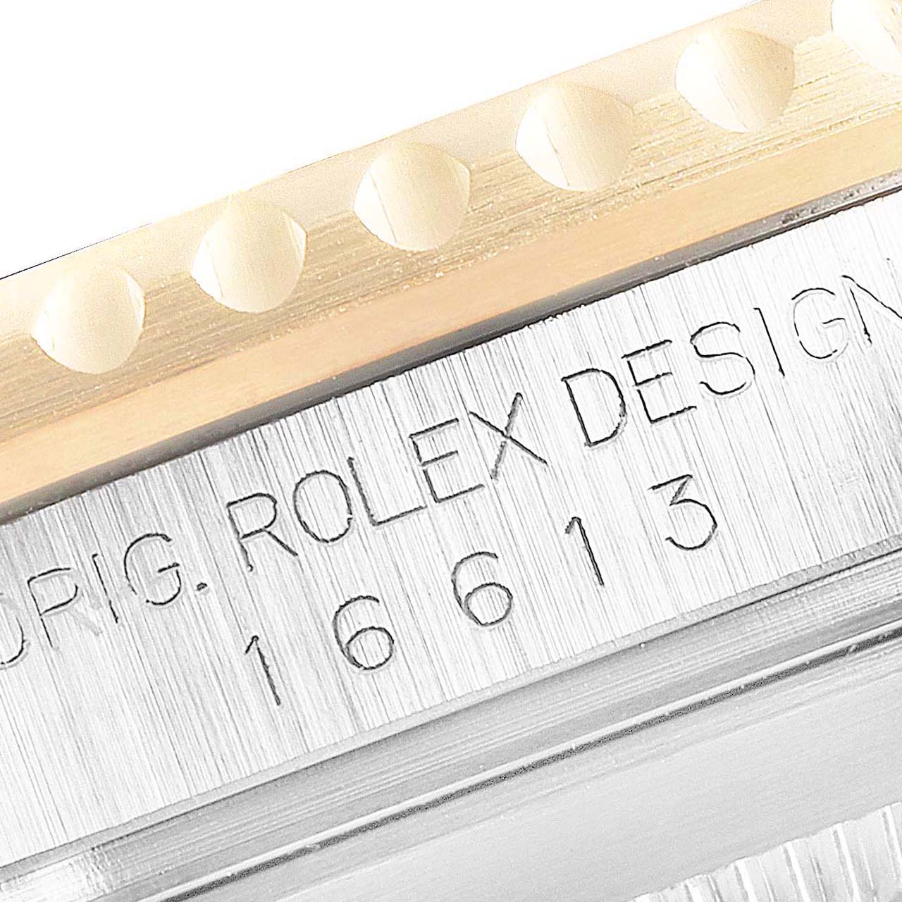 This image shows a close-up of the bezel and engraved case side of a Rolex Submariner 16613 Men's Steel and Gold (two tone) Black Dial 16613 Men's Steel and Gold (two tone) Black Dial model.