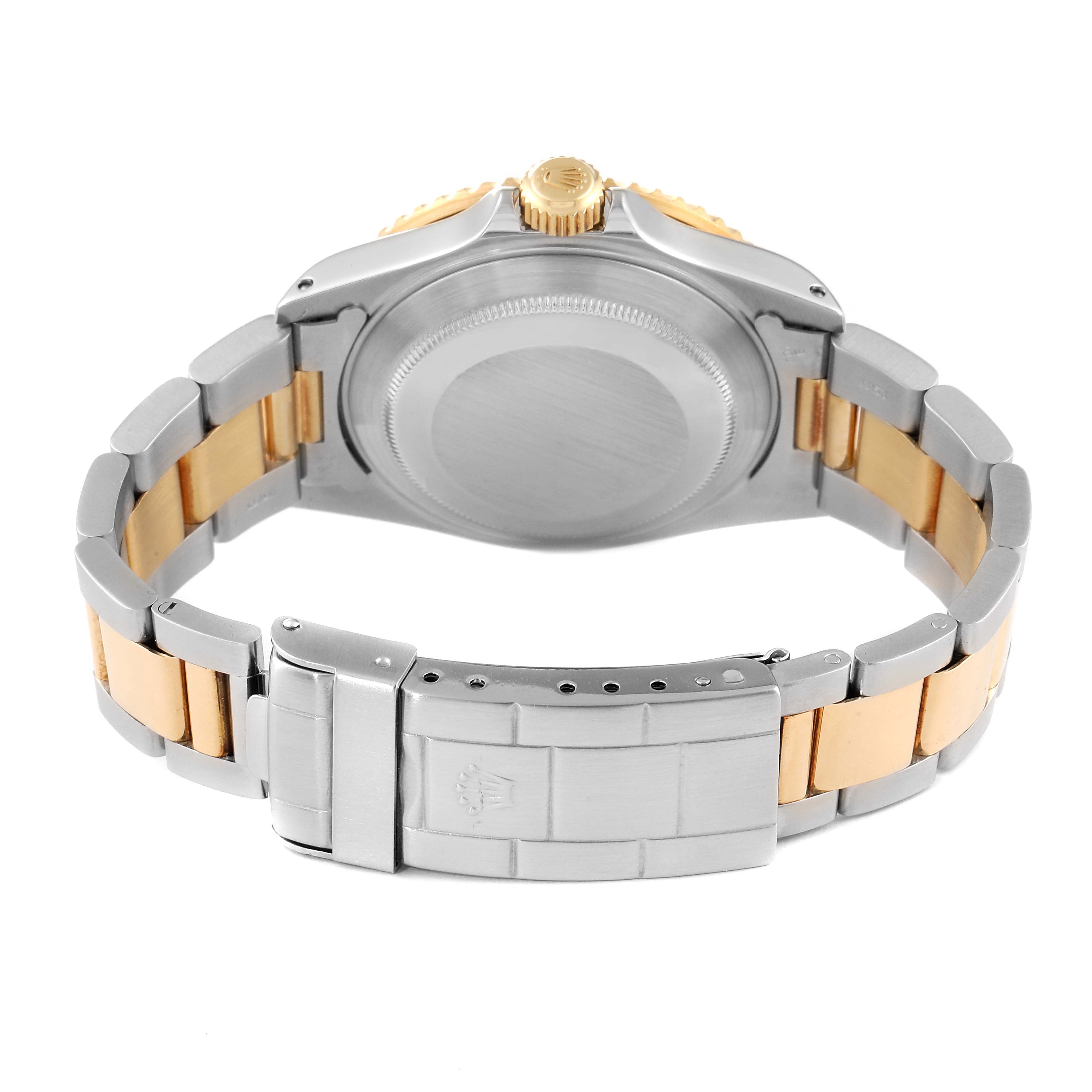 The image shows the back case and band clasp of the Rolex Submariner 16613 Men's Steel and Gold (two tone) Black Dial 16613 Men's Steel and Gold (two tone) Black Dial watch at an angle.