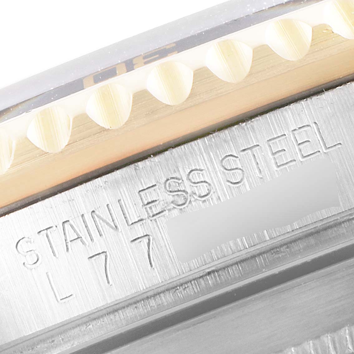 This close-up image of a Rolex Submariner 16613 Men's Steel and Gold (two tone) Black Dial 16613 Men's Steel and Gold (two tone) Black Dial watch shows part of the stainless steel case with some engravings.