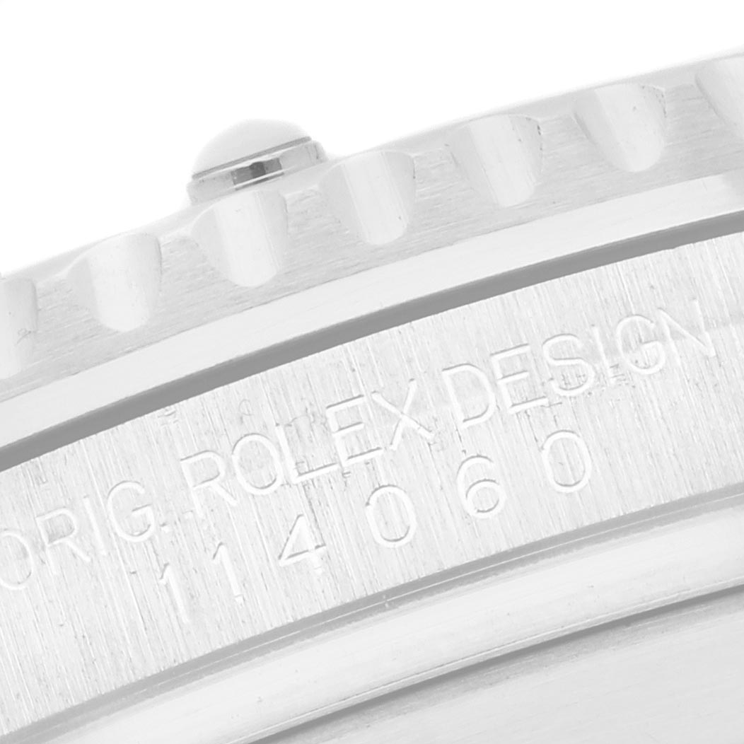 The image shows a close-up of the engraved side of a Rolex Submariner 114060 Men's Stainless Steel Black Dial 114060 Men's Stainless Steel Black Dial watch bezel and case.