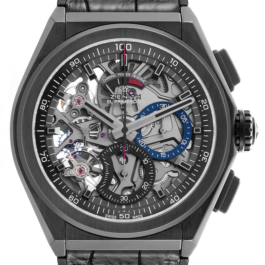 The Zenith Defy watch is shown from a front angle, highlighting its skeleton dial and chronograph features.