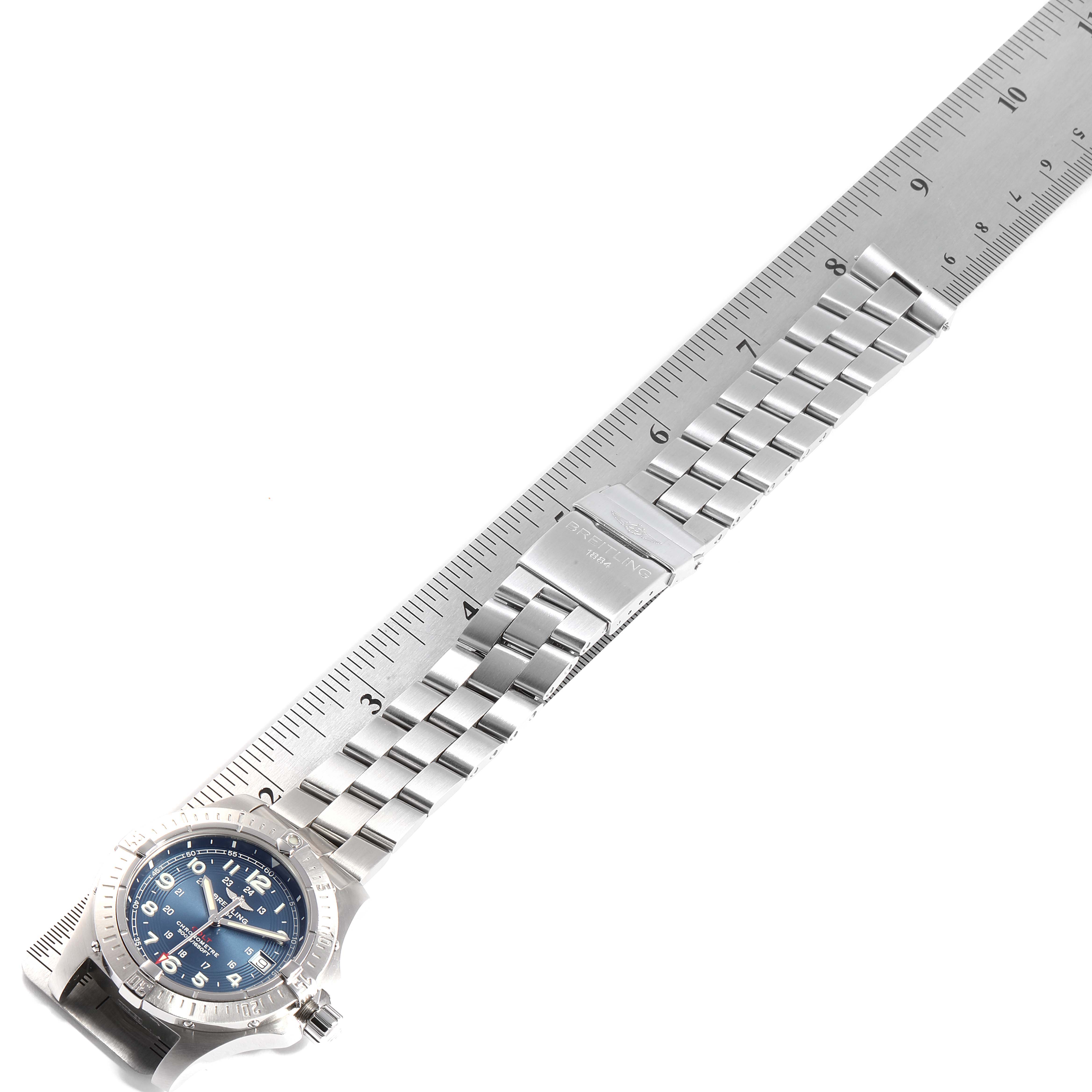 The image shows the Breitling Colt A74380 Men's Stainless Steel Blue Dial A74380 Men's Stainless Steel Blue Dial watch lying flat with its metal bracelet extended along a ruler, highlighting the clasp and bracelet length.