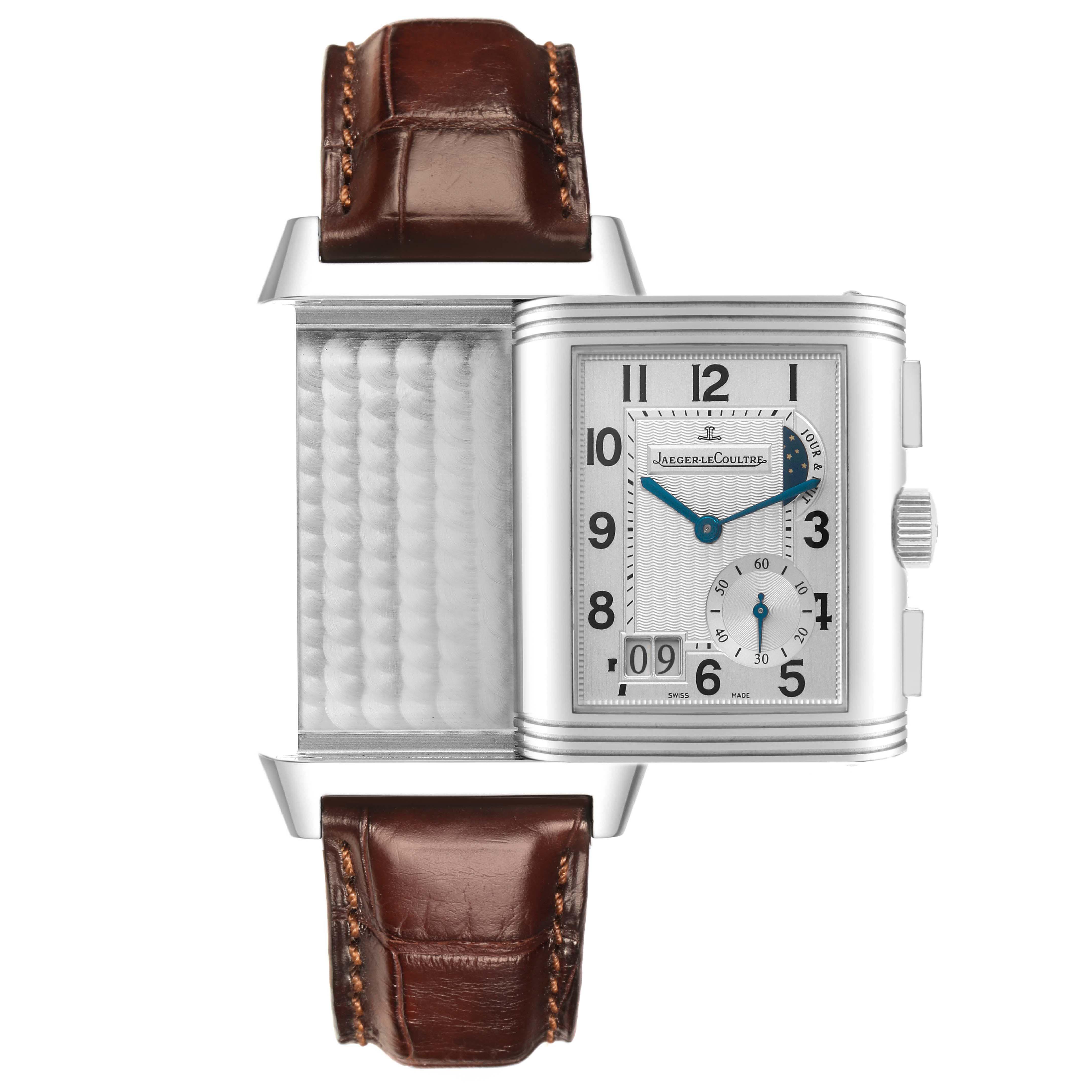 The Jaeger-LeCoultre Reverso watch is shown with a rotated case, displaying both the dial and the signature reversing mechanism.