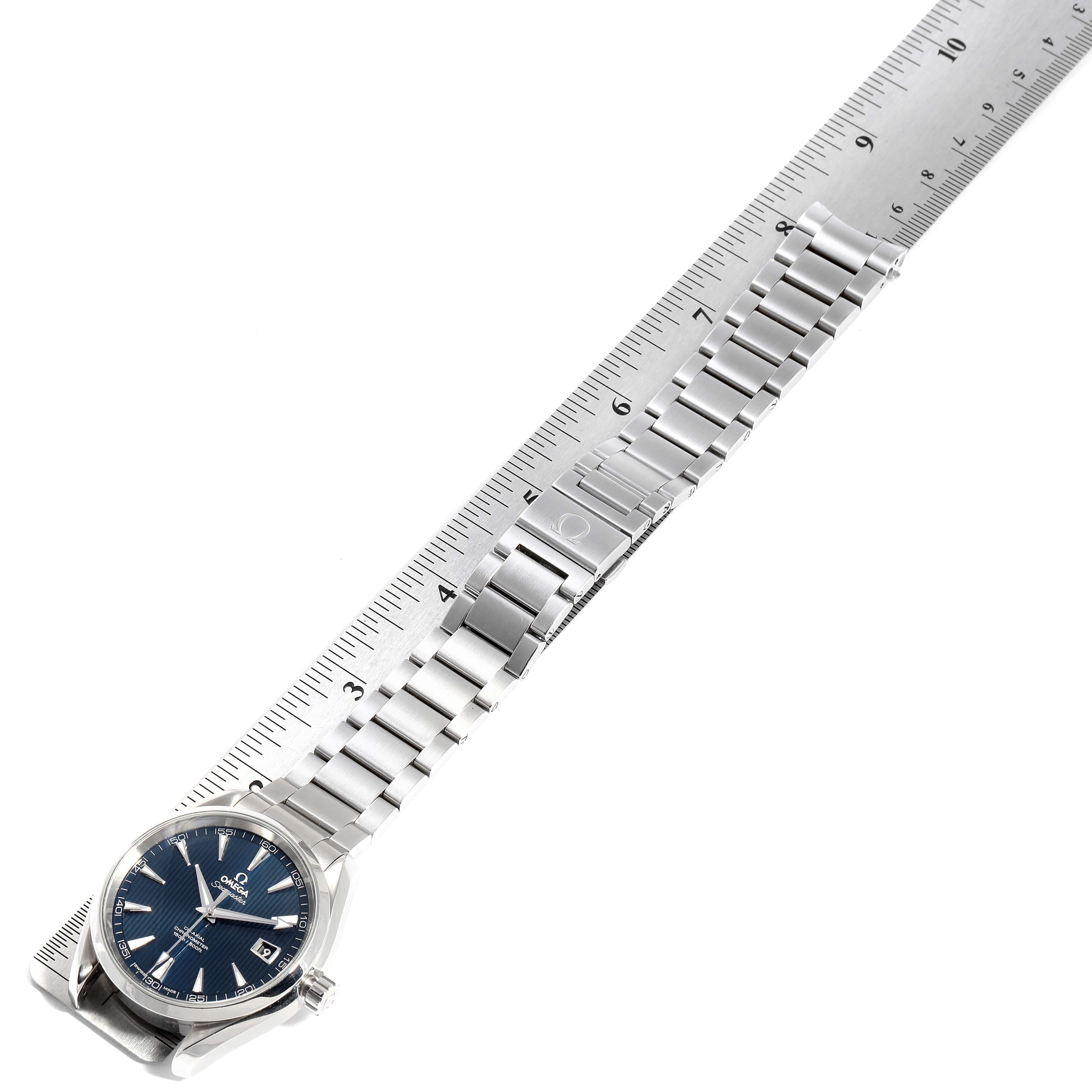 This image shows an Omega Aqua Terra 231.10.42.21.03.001 Men
s Stainless Steel Blue Dial 231.10.42.21.03.001 Men
s Stainless Steel Blue Dial watch laid flat, with its stainless steel bracelet fully extended along a ruler.